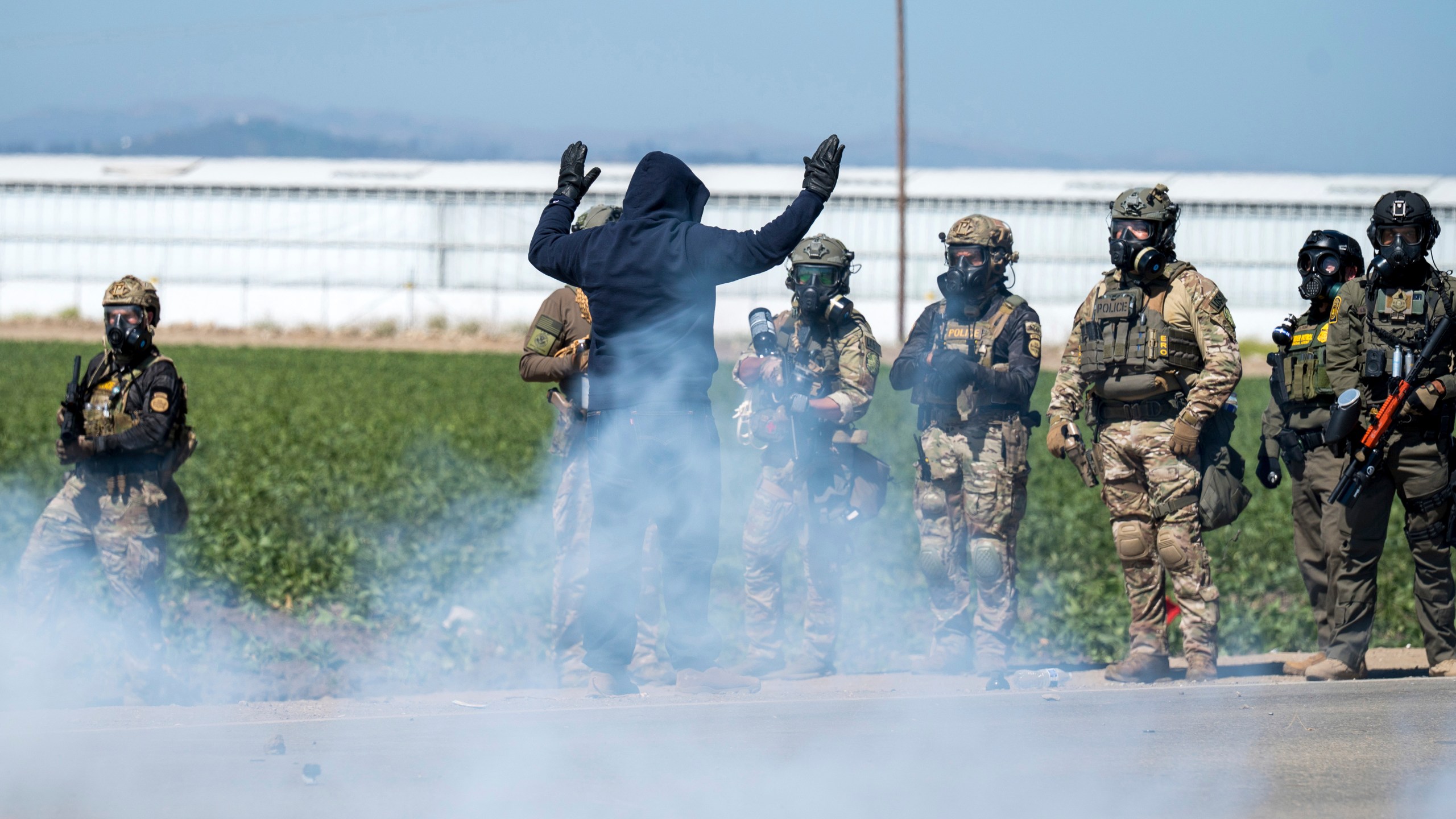 FILE - Federal immigration agents toss tear gas at protesters during a raid in the agriculture area of Camarillo, Calif., Thursday, July 10, 2025. (AP Photo/Michael Owen Baker, File)