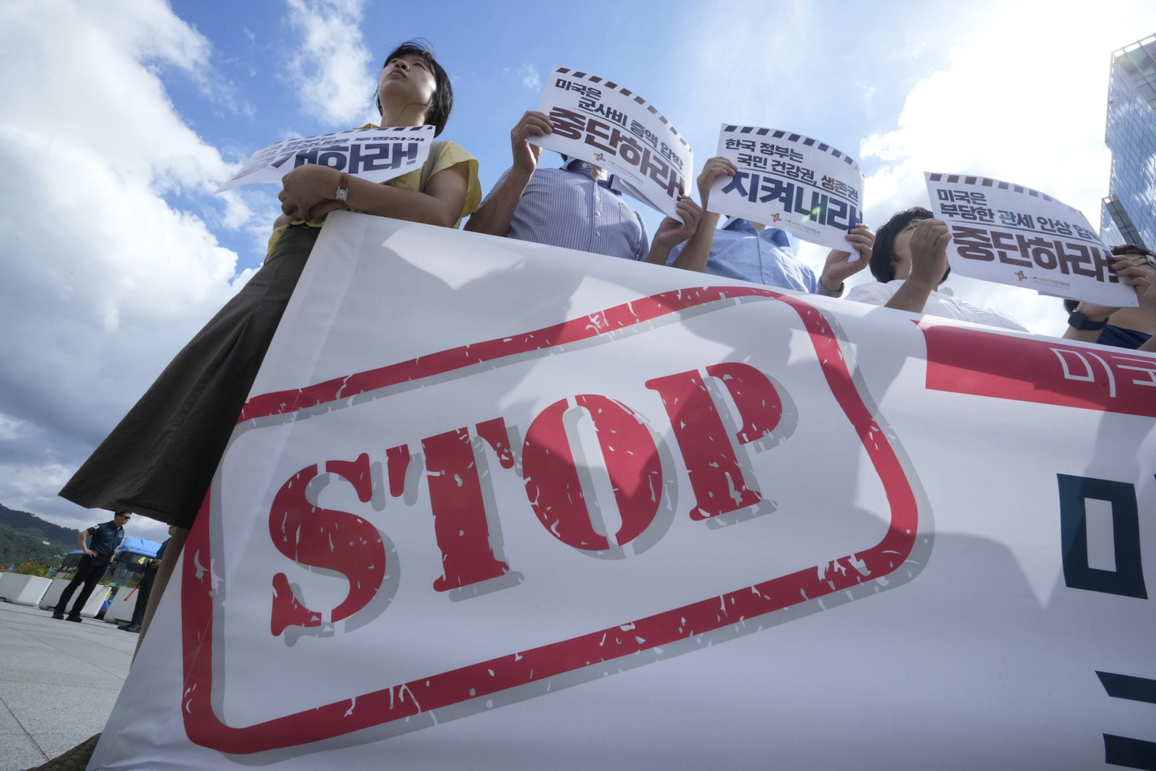 Members of civic groups protest against U.S. President Donald Trump's tariffs policy on South Korea, near the U.S. embassy in Seoul, South Korea, Tuesday, July 22, 2025. The banners reads " The U.S. should stop raising unfair tariffs and pressuring for increased military spending."(AP Photo/Ahn Young-joon)