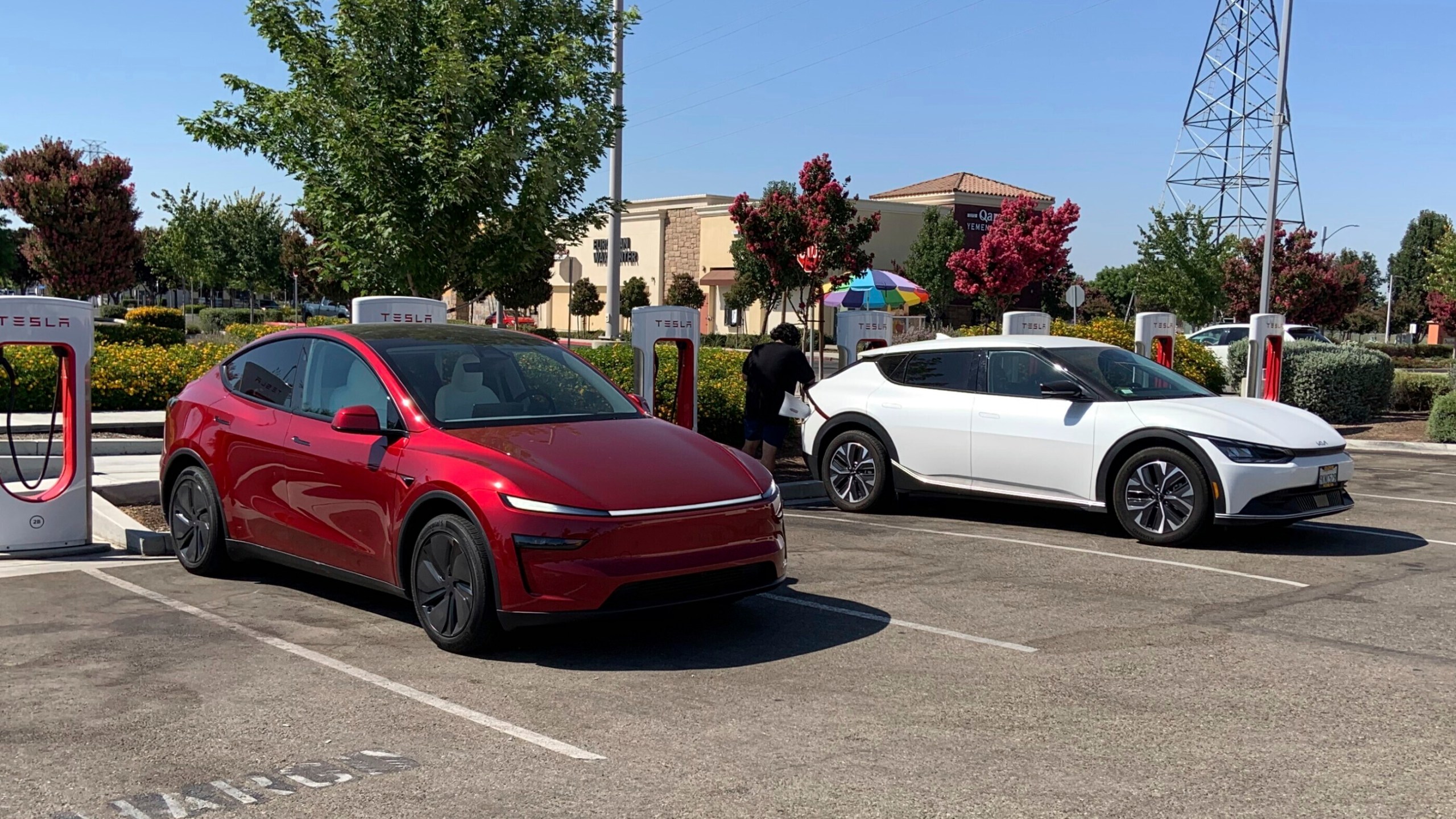 This photo provided by Edmunds shows a Tesla Model Y and a Kia EV6 parked at a Tesla Supercharger station in Fresno, Calif. Planning a cross-country trip in an EV takes extra effort, but doing it properly can make the journey almost as smooth as in a gas-powered vehicle. (Courtesy of Edmunds via AP)