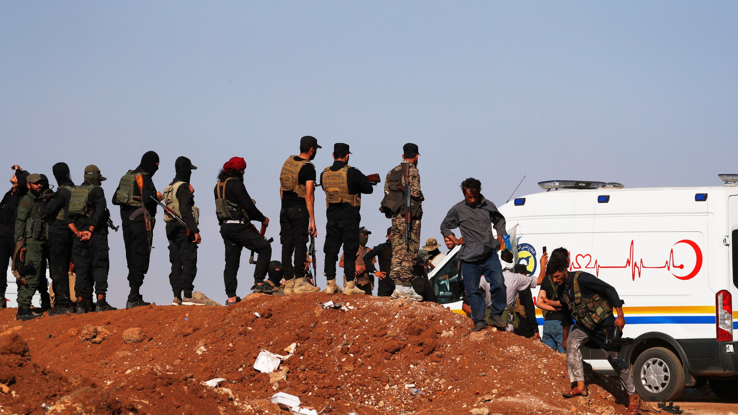A convoy of ambulances and buses arrives at a checkpoint in the village of Busra al-Harir, southern Syria, on its way to Sweida province, as security forces cordon off the area to block Bedouin fighters from entering the province, Tuesday, July 22, 2025. (AP Photo/Omar Sanadiki)
