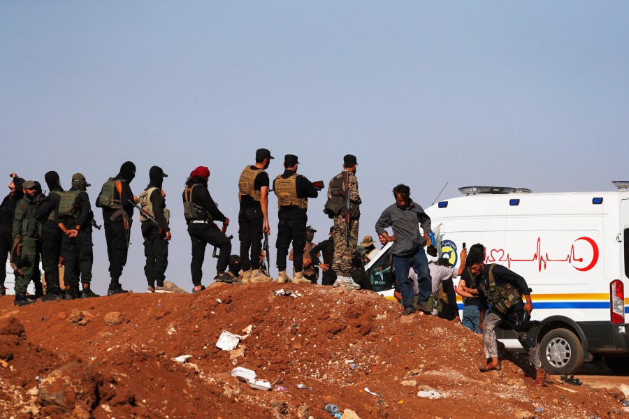 A convoy of ambulances and buses arrives at a checkpoint in the village of Busra al-Harir, southern Syria, on its way to Sweida province, as security forces cordon off the area to block Bedouin fighters from entering the province, Tuesday, July 22, 2025. (AP Photo/Omar Sanadiki)