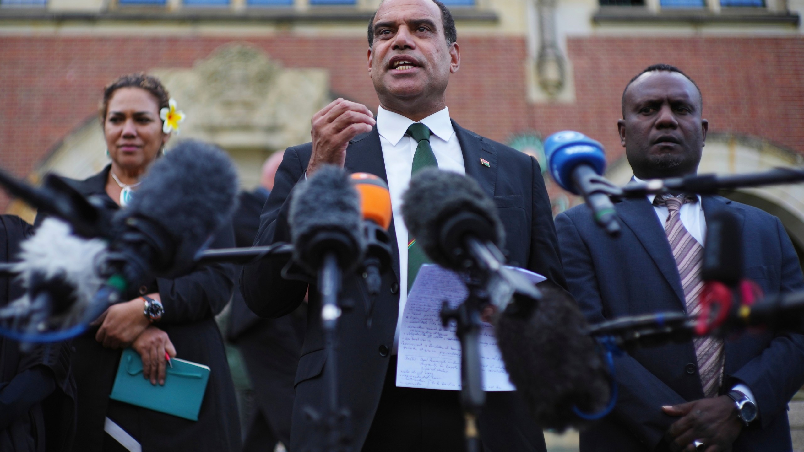 Ralph Regenvanu, center, Vanuatu's minister for climate change, speaks after the International Court of Justice's advisory opinion about nations' obligations to tackle climate change and consequences they may face if they don't, Wednesday, July 23, 2025, in The Hague, Netherlands. (AP Photo/Peter Dejong)