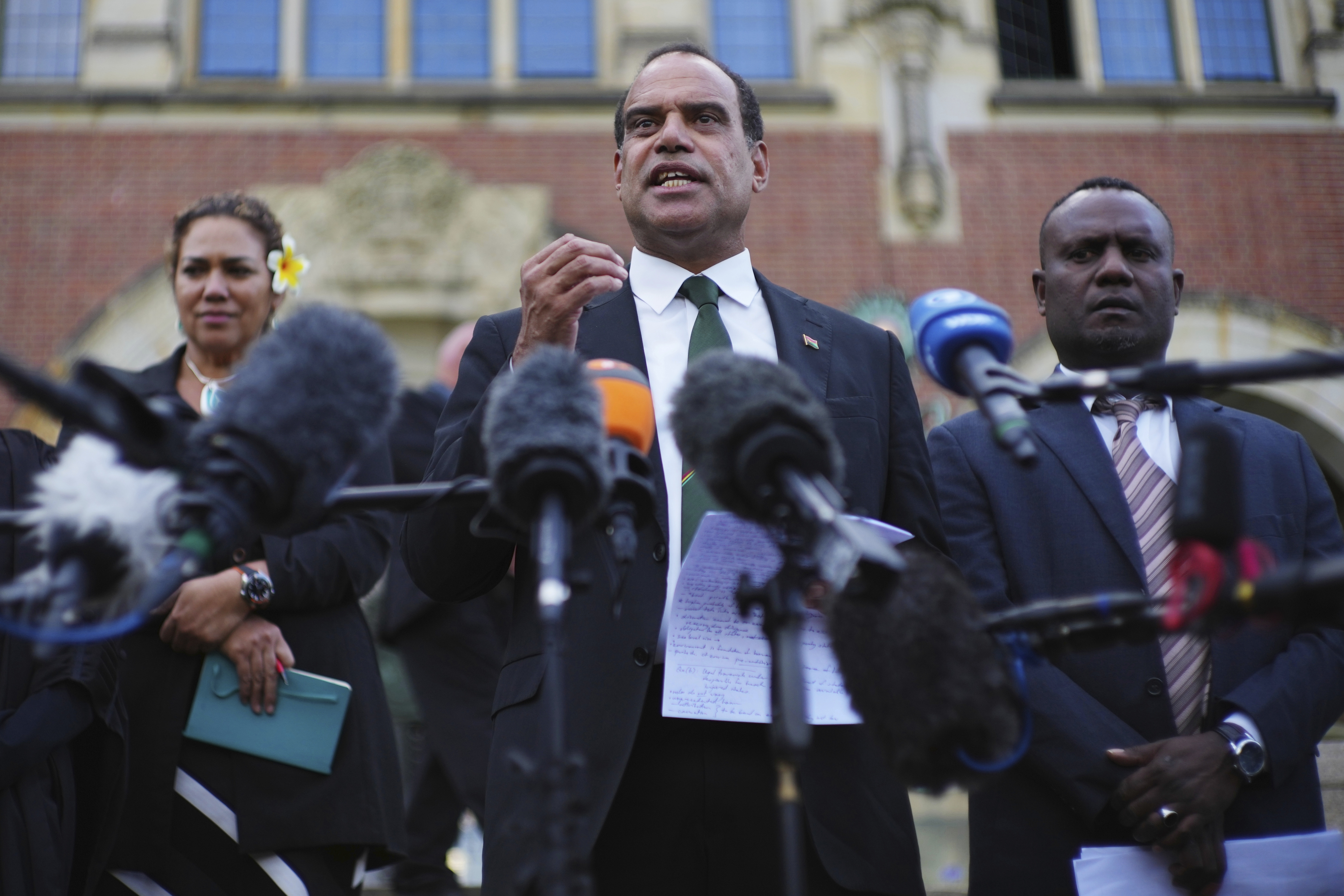 Ralph Regenvanu, center, Vanuatu's minister for climate change, speaks after the International Court of Justice's advisory opinion about nations' obligations to tackle climate change and consequences they may face if they don't, Wednesday, July 23, 2025, in The Hague, Netherlands. (AP Photo/Peter Dejong)