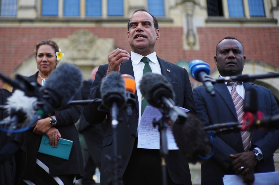 Ralph Regenvanu, center, Vanuatu's minister for climate change, speaks after the International Court of Justice's advisory opinion about nations' obligations to tackle climate change and consequences they may face if they don't, Wednesday, July 23, 2025, in The Hague, Netherlands. (AP Photo/Peter Dejong)