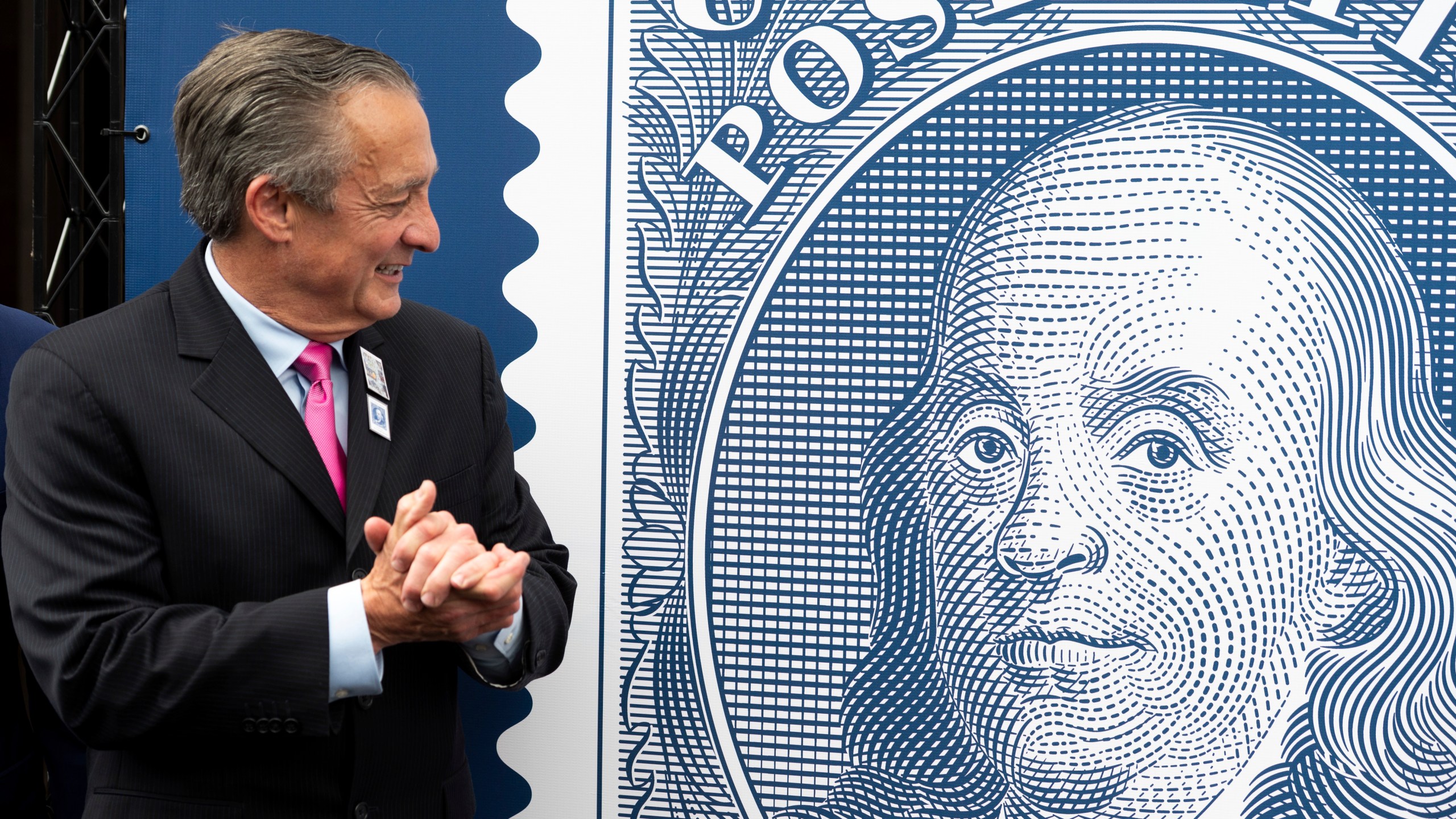 Postmaster General David Steiner looks at a just unveiled Benjamin Franklin stamp to mark the 250th anniversary of postal service's founding, Wednesday, July 23, 2025, in Washington. (AP Photo/Cliff Owen)