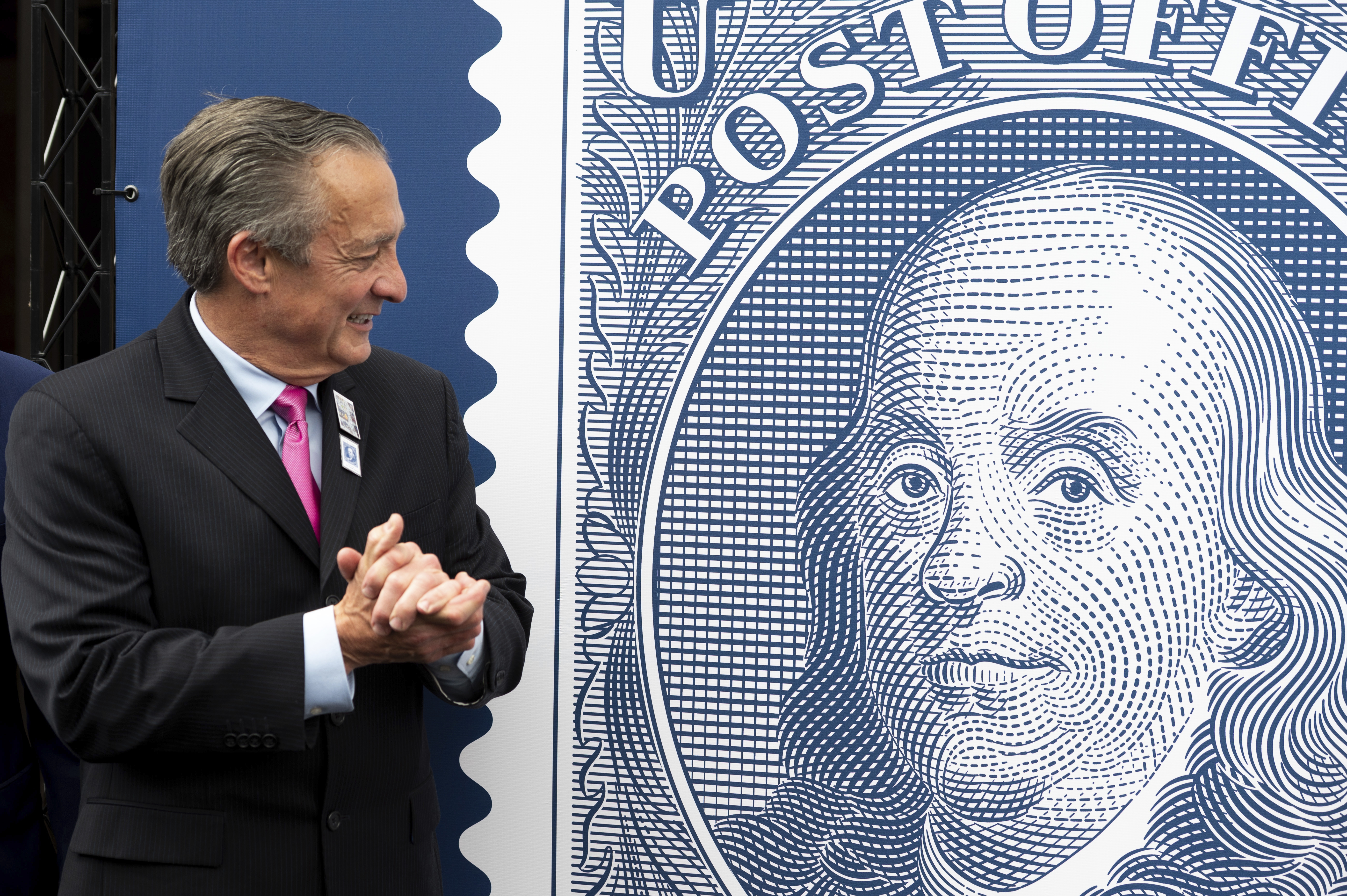 Postmaster General David Steiner looks at a just unveiled Benjamin Franklin stamp to mark the 250th anniversary of postal service's founding, Wednesday, July 23, 2025, in Washington. (AP Photo/Cliff Owen)