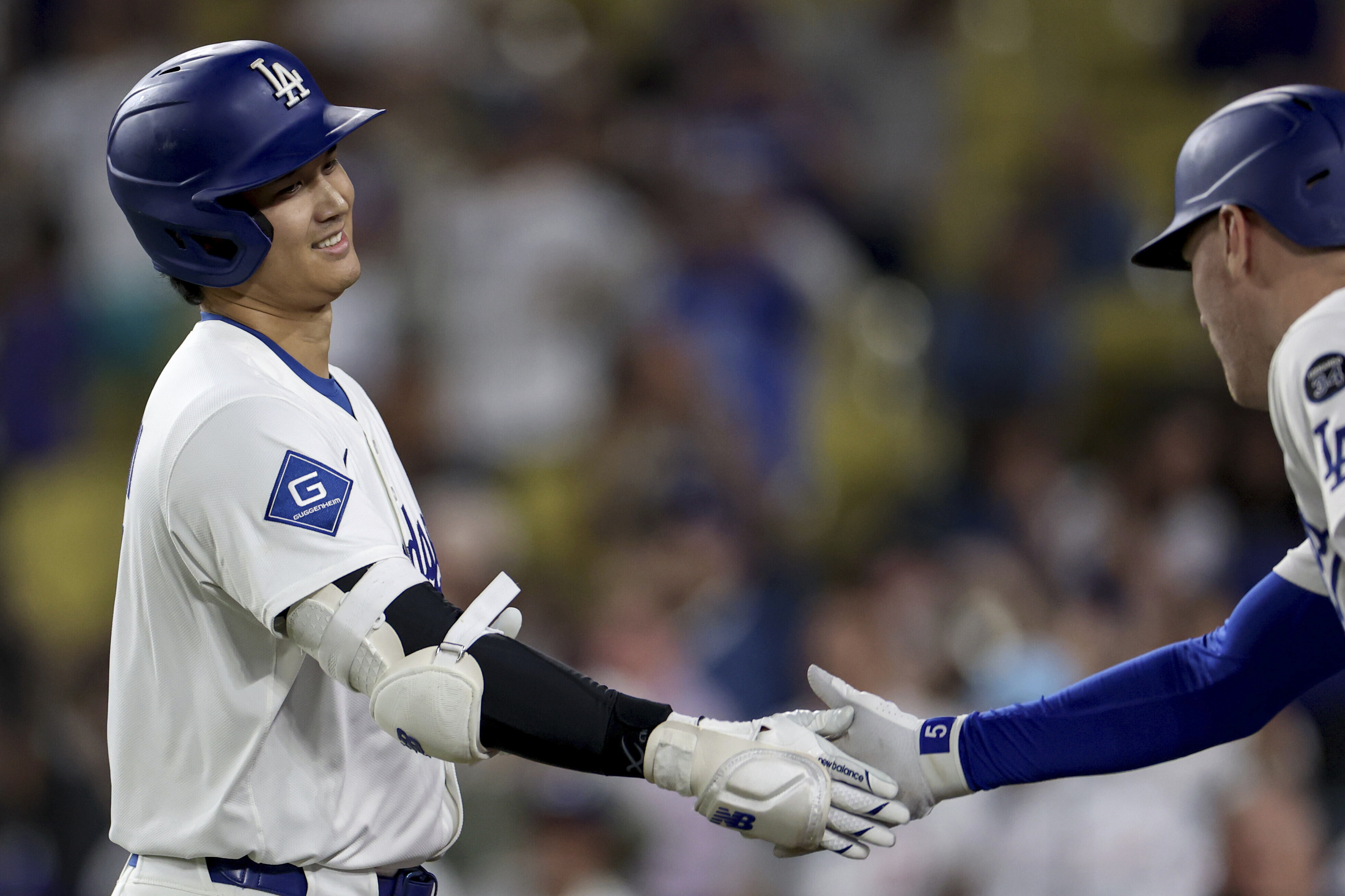 Los Angeles Dodgers designated hitter Shohei Ohtani is congratulated by teammate Freddie Freeman after hitting a home run during the ninth inning of a baseball game against the Minnesota Twins Tuesday, July 22, 2025, in Los Angeles. (AP Photo/Eric Thayer)