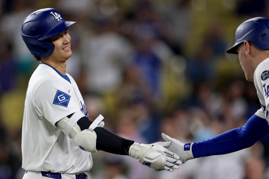 Los Angeles Dodgers designated hitter Shohei Ohtani is congratulated by teammate Freddie Freeman after hitting a home run during the ninth inning of a baseball game against the Minnesota Twins Tuesday, July 22, 2025, in Los Angeles. (AP Photo/Eric Thayer)