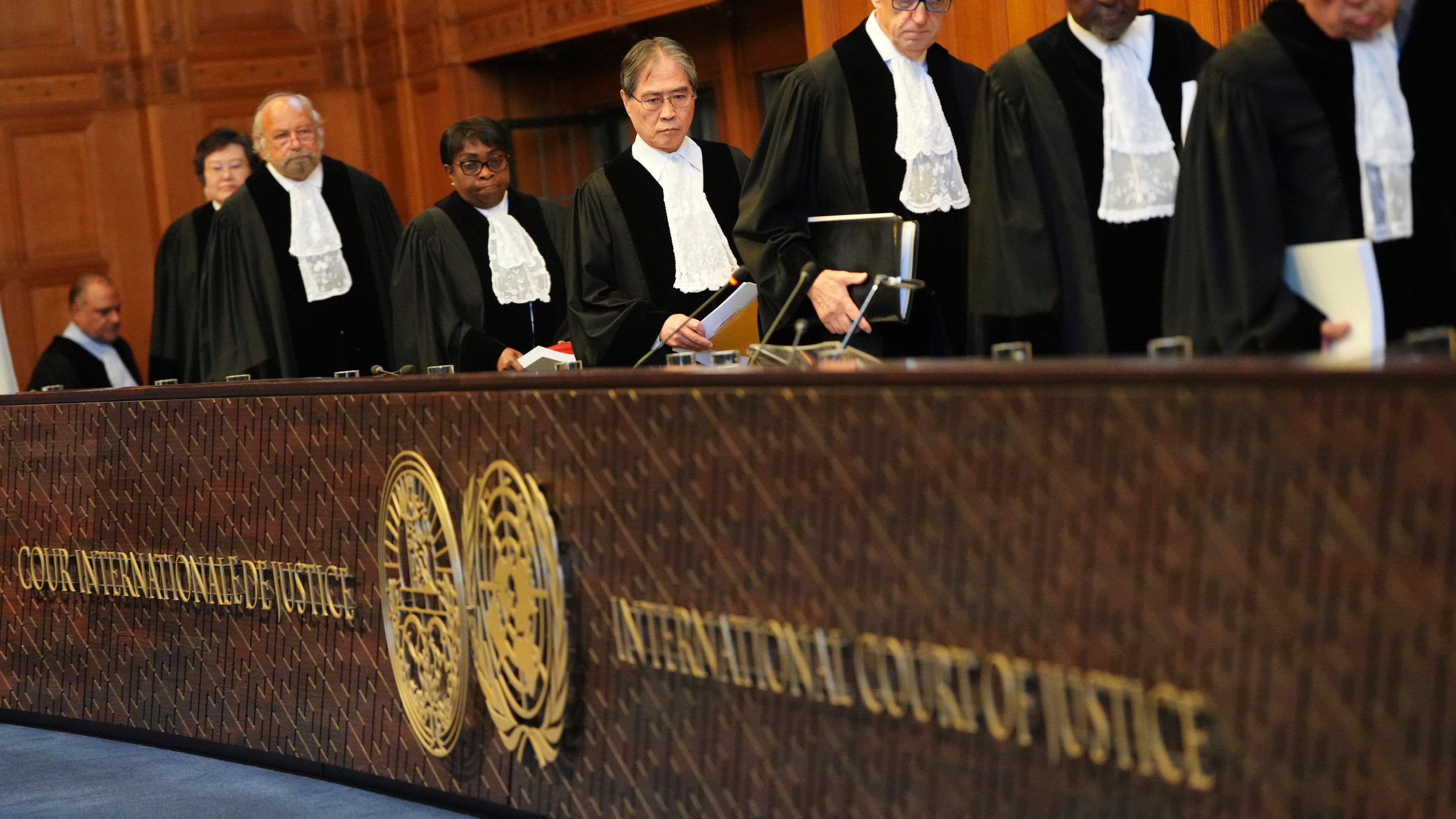 Presiding judge Yuji Iwasawa, fourth from right, enters the International Court of Justice ahead of an advisory opinion on what legal obligations nations have to address climate change and what consequences they may face if they don't, Wednesday, July 23, 2025, in The Hague, Netherlands. (AP Photo/Peter Dejong)