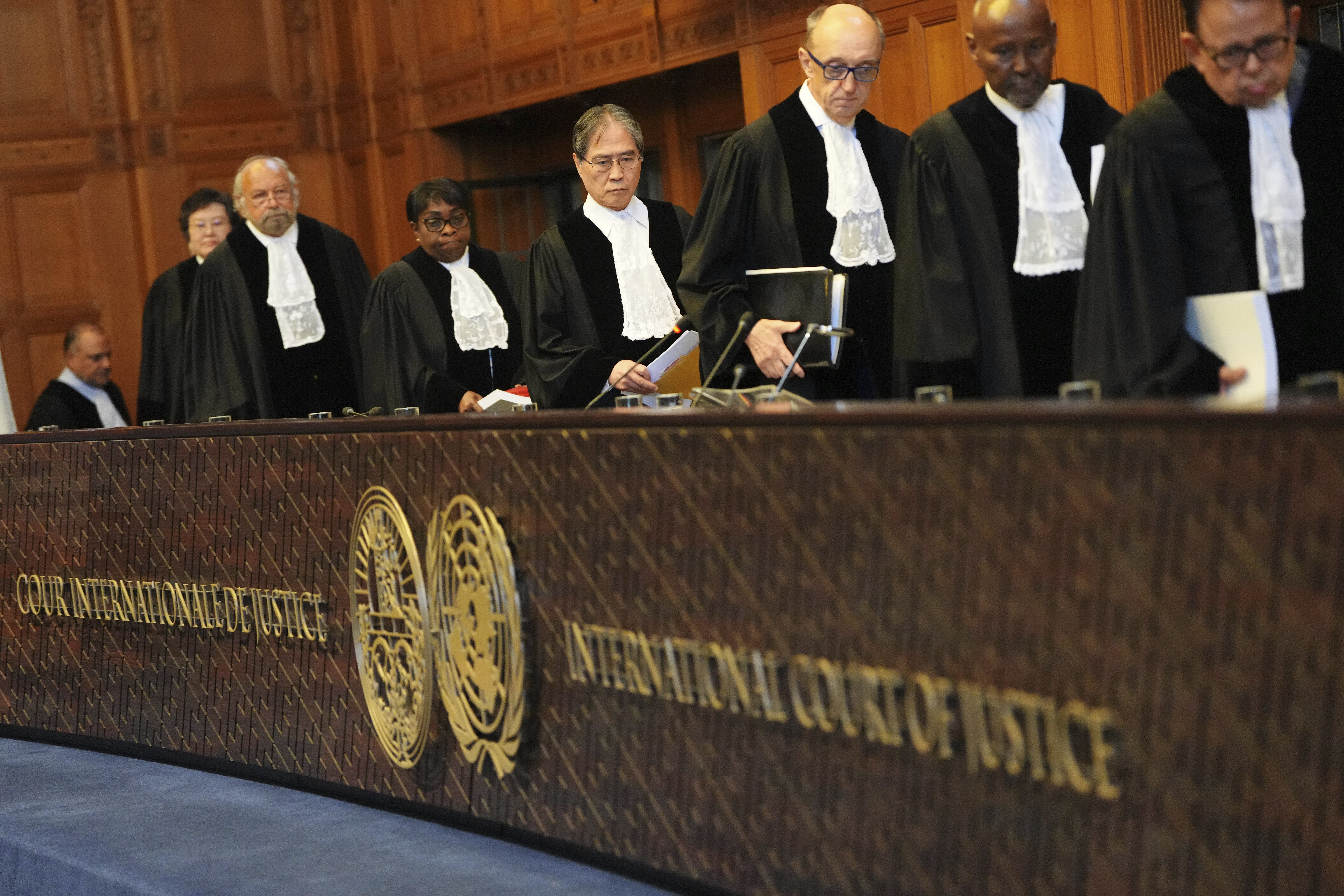 Presiding judge Yuji Iwasawa, fourth from right, enters the International Court of Justice ahead of an advisory opinion on what legal obligations nations have to address climate change and what consequences they may face if they don't, Wednesday, July 23, 2025, in The Hague, Netherlands. (AP Photo/Peter Dejong)