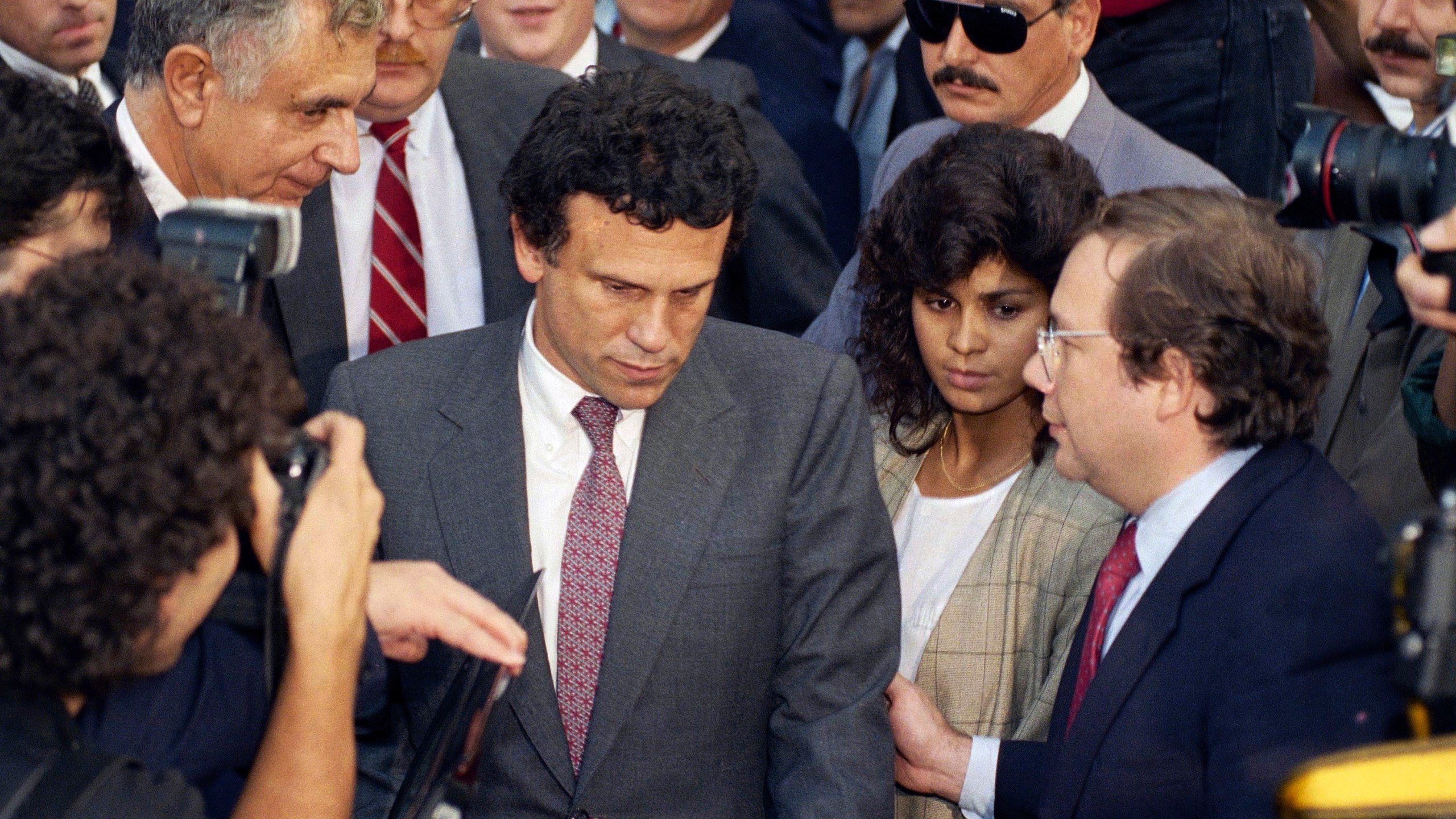 FILE - Financier Michael Milken, center, leaves U.S. District Court in Manhattan after the first day of pre-sentencing hearings in New York, Oct. 12, 1990. (AP Photo/Mark Lennihan, File)
