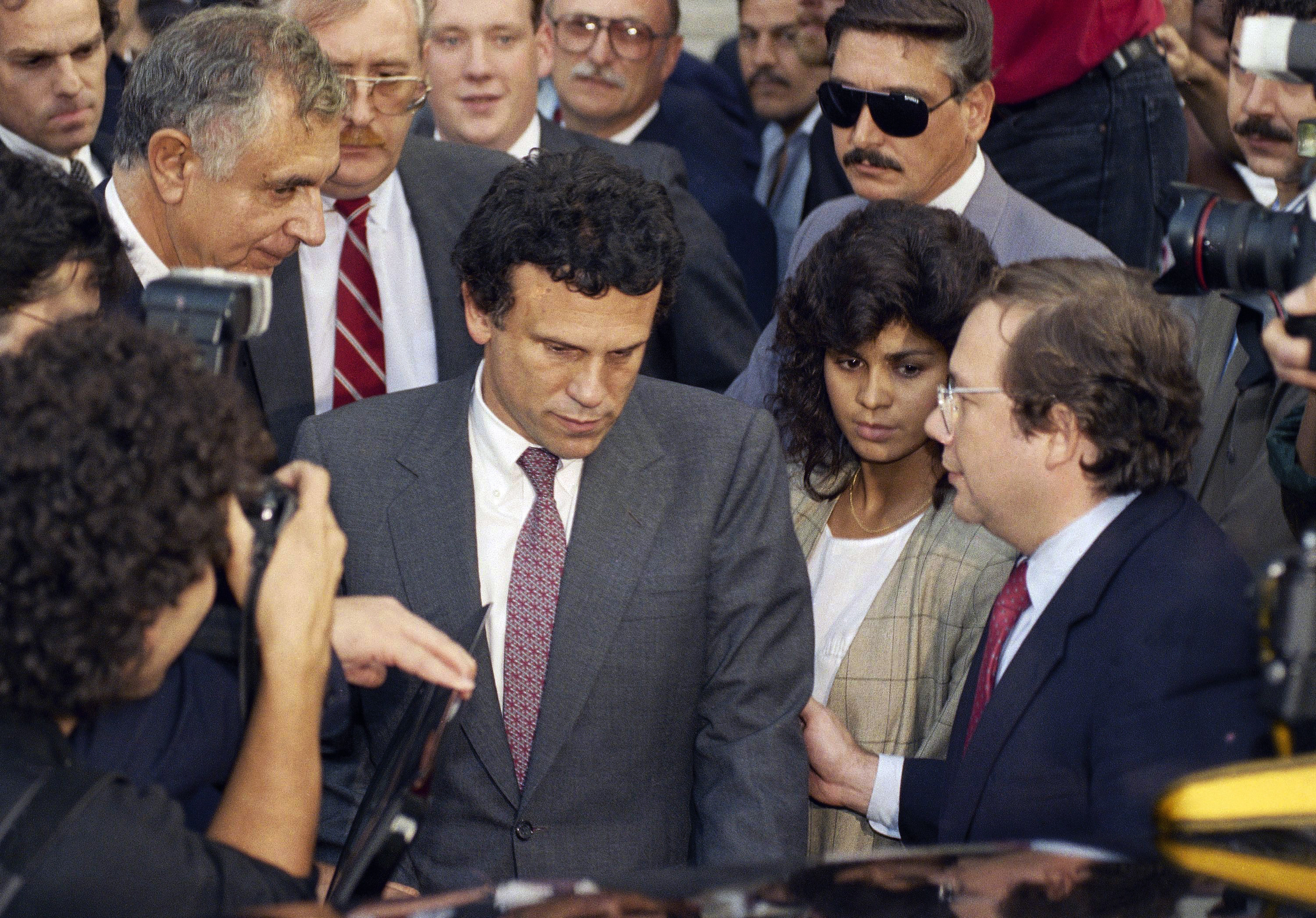 FILE - Financier Michael Milken, center, leaves U.S. District Court in Manhattan after the first day of pre-sentencing hearings in New York, Oct. 12, 1990. (AP Photo/Mark Lennihan, File)