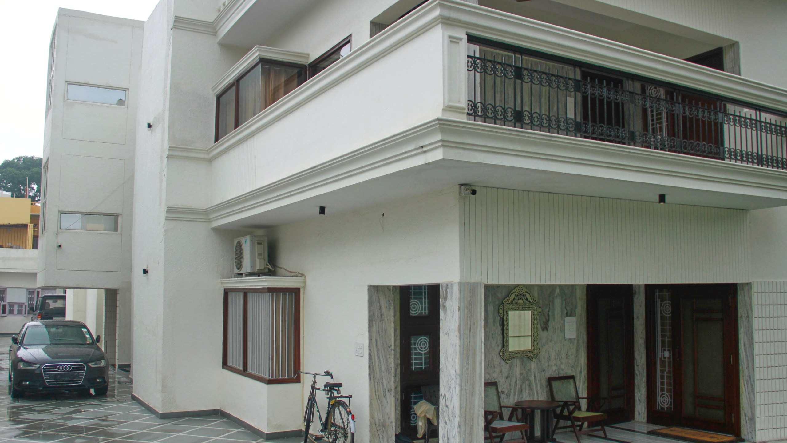 A luxury car and a bicycle are seen parked outside a rented residential building in which a bogus embassy was running in Ghaziabad, outskirts of New Delhi, India, Wednesday, July 23, 2025. (AP Photo)