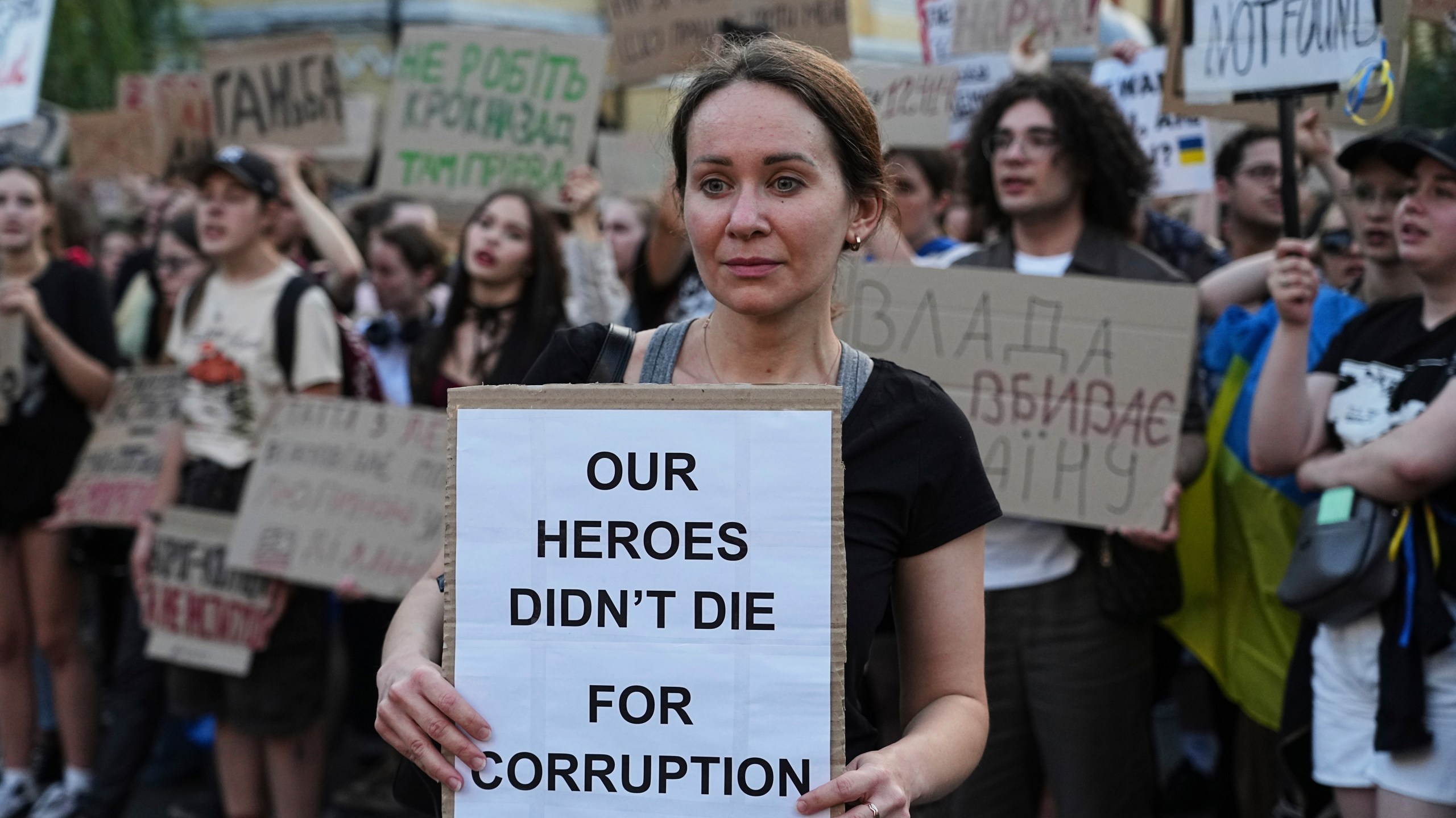 A woman holds a banner during a protest against a law targeting anti-corruption institutions in central Kyiv, Ukraine, Wednesday, July 23, 2025. (AP Photo/Efrem Lukatsky)