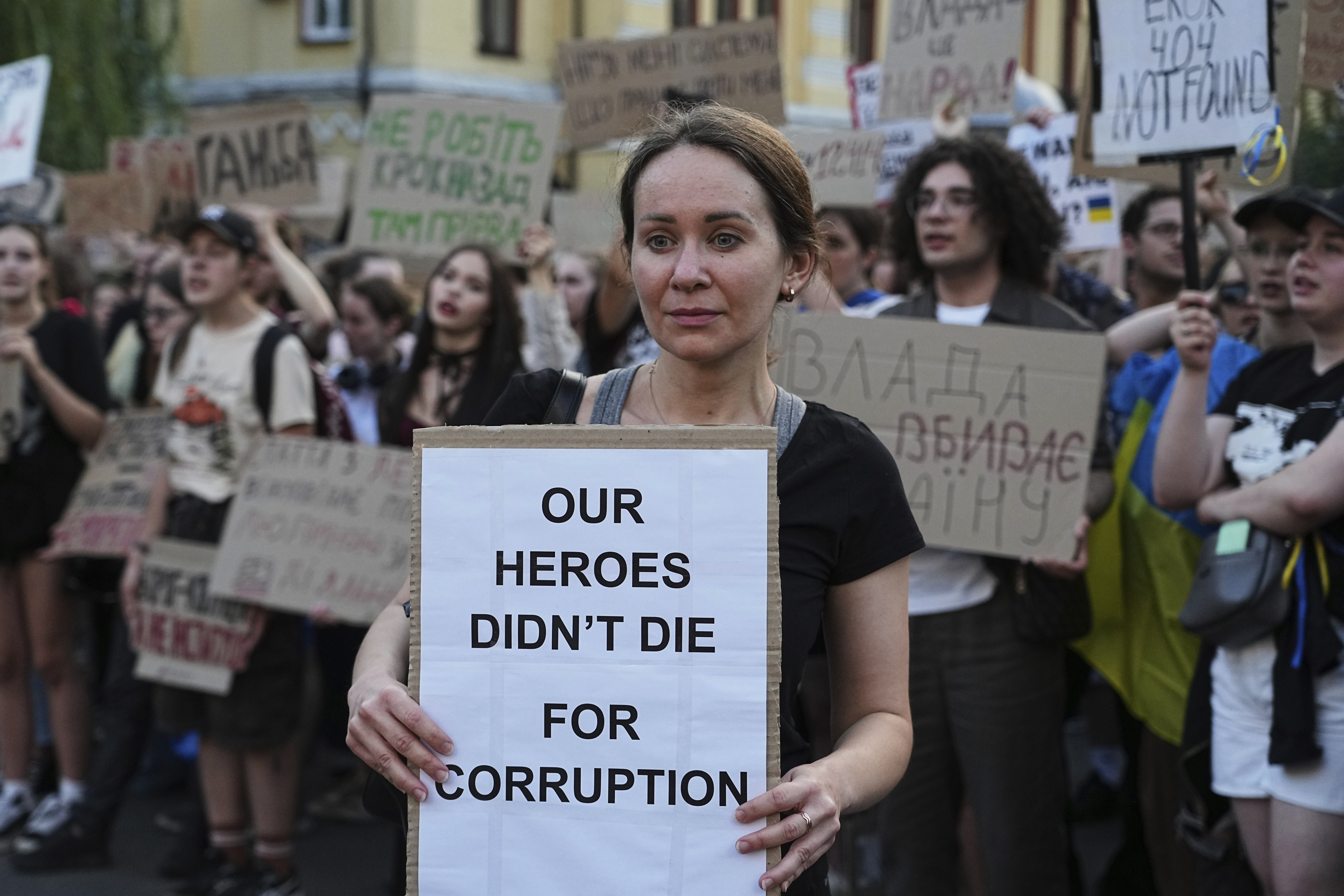 A woman holds a banner during a protest against a law targeting anti-corruption institutions in central Kyiv, Ukraine, Wednesday, July 23, 2025. (AP Photo/Efrem Lukatsky)