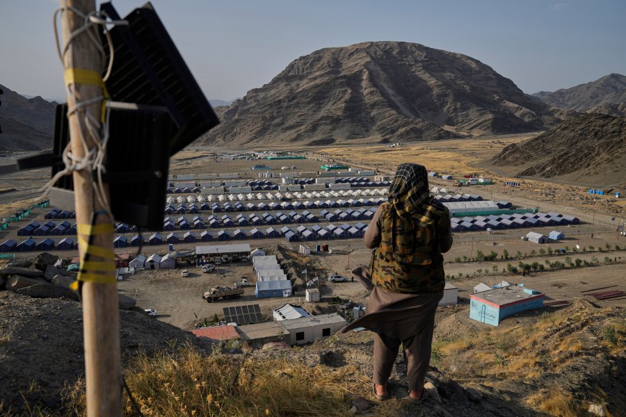 FILE -A Taliban fighter stands on a hill overlooking a camp housing Afghan refugees who have been repatriated from Pakistan, near the Pakistan-Afghanistan border, in Torkham, Afghanistan, May 31, 2025. (AP Photo/Ebrahim Noroozi, File)