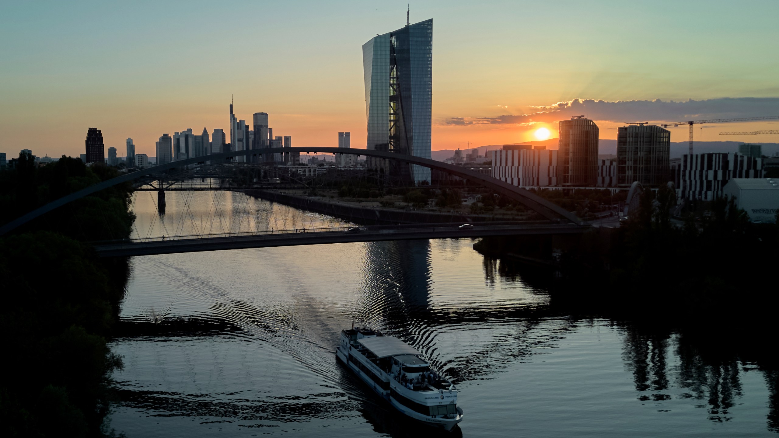 FILE - The sun sets behind the European Central Bank, right, and the buildings of the banking district in Frankfurt, Germany, Tuesday, July 1, 2025. (AP Photo/Michael Probst, file)