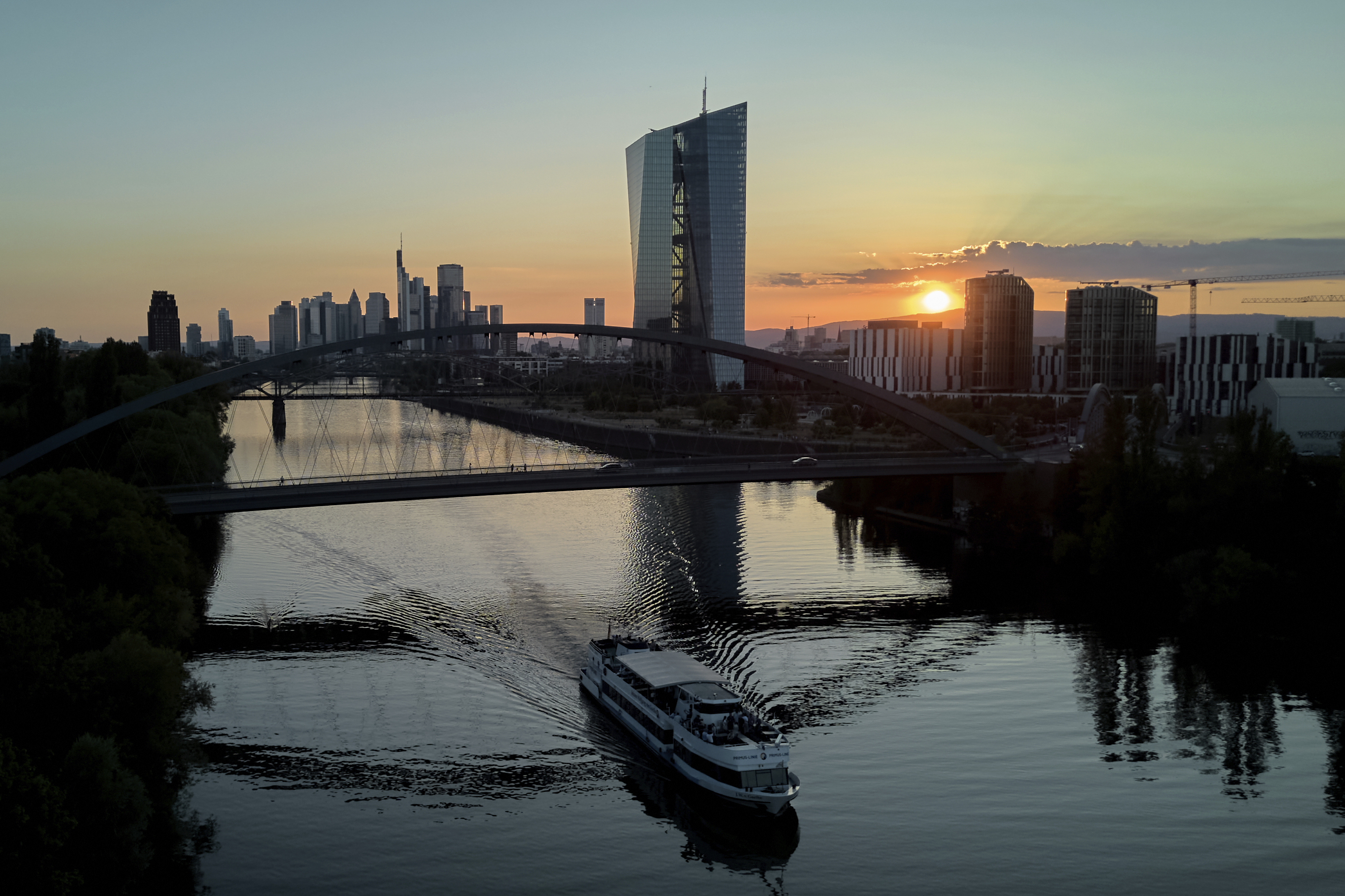 FILE - The sun sets behind the European Central Bank, right, and the buildings of the banking district in Frankfurt, Germany, Tuesday, July 1, 2025. (AP Photo/Michael Probst, file)