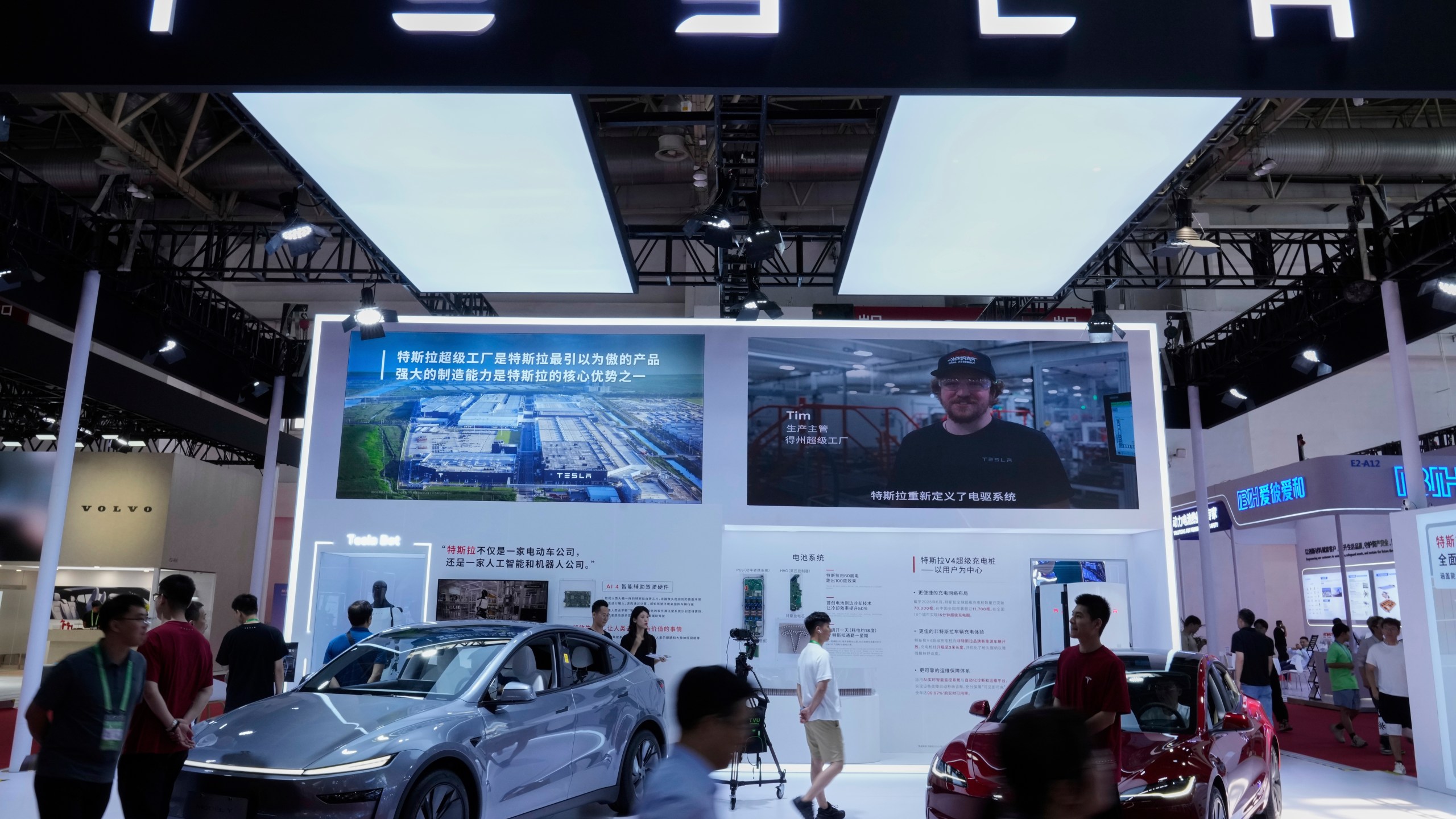 People visit a booth of Tesla during the 3rd China International Supply Chain Expo at the China International Exhibition Center, in Beijing, China, Friday, July 18, 2025. (AP Photo/Mahesh Kumar A.)