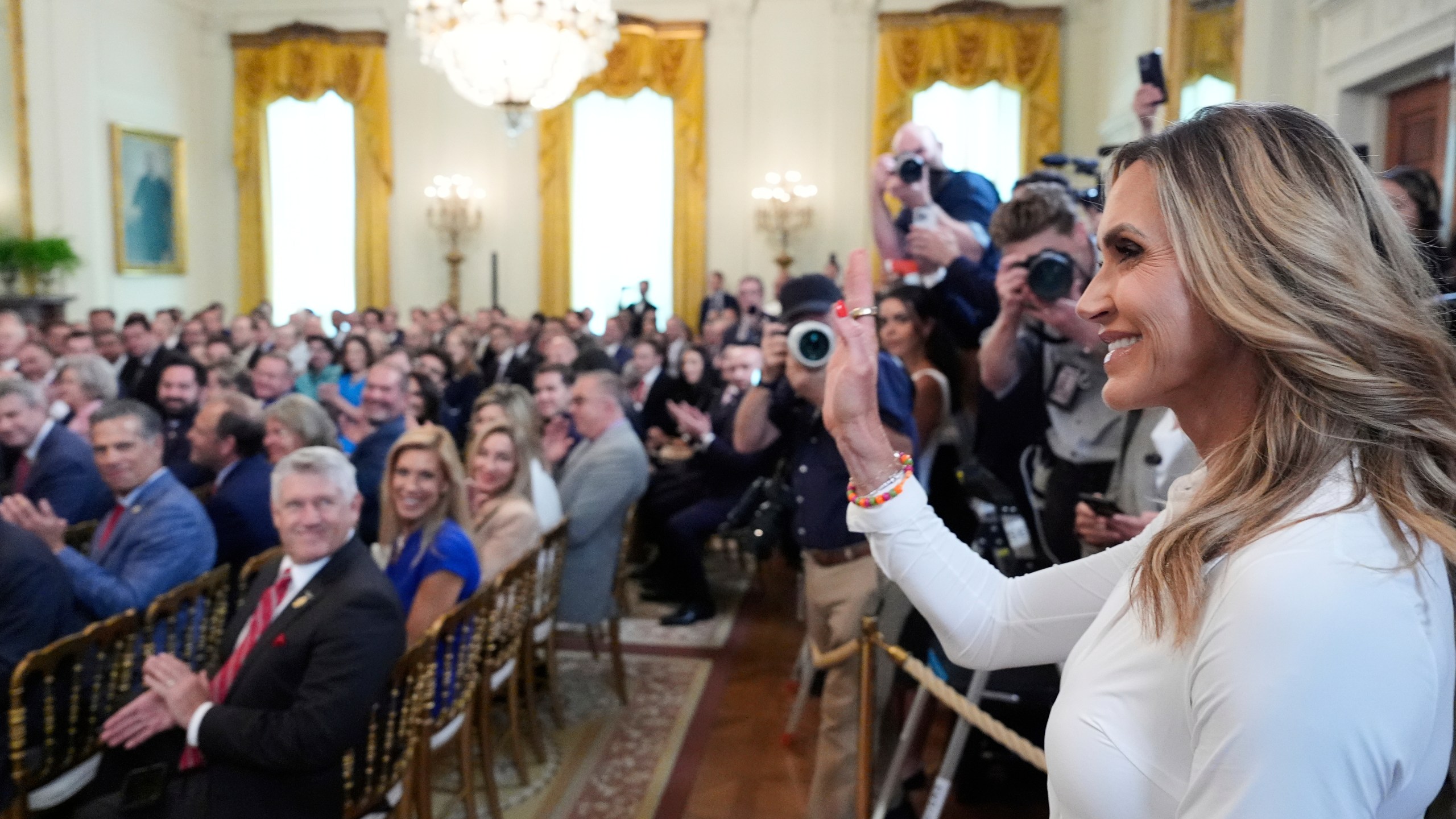 Lara Trump waves to the audience as President Donald Trump speaks at an event for the signing of the GENIUS Act, a bill that regulates stablecoins, a type of cryptocurrency, in the East Room of the White House, Friday, July 18, 2025, in Washington. (AP Photo/Alex Brandon)