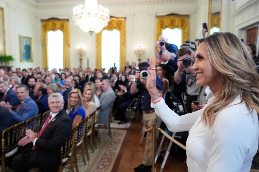 Lara Trump waves to the audience as President Donald Trump speaks at an event for the signing of the GENIUS Act, a bill that regulates stablecoins, a type of cryptocurrency, in the East Room of the White House, Friday, July 18, 2025, in Washington. (AP Photo/Alex Brandon)