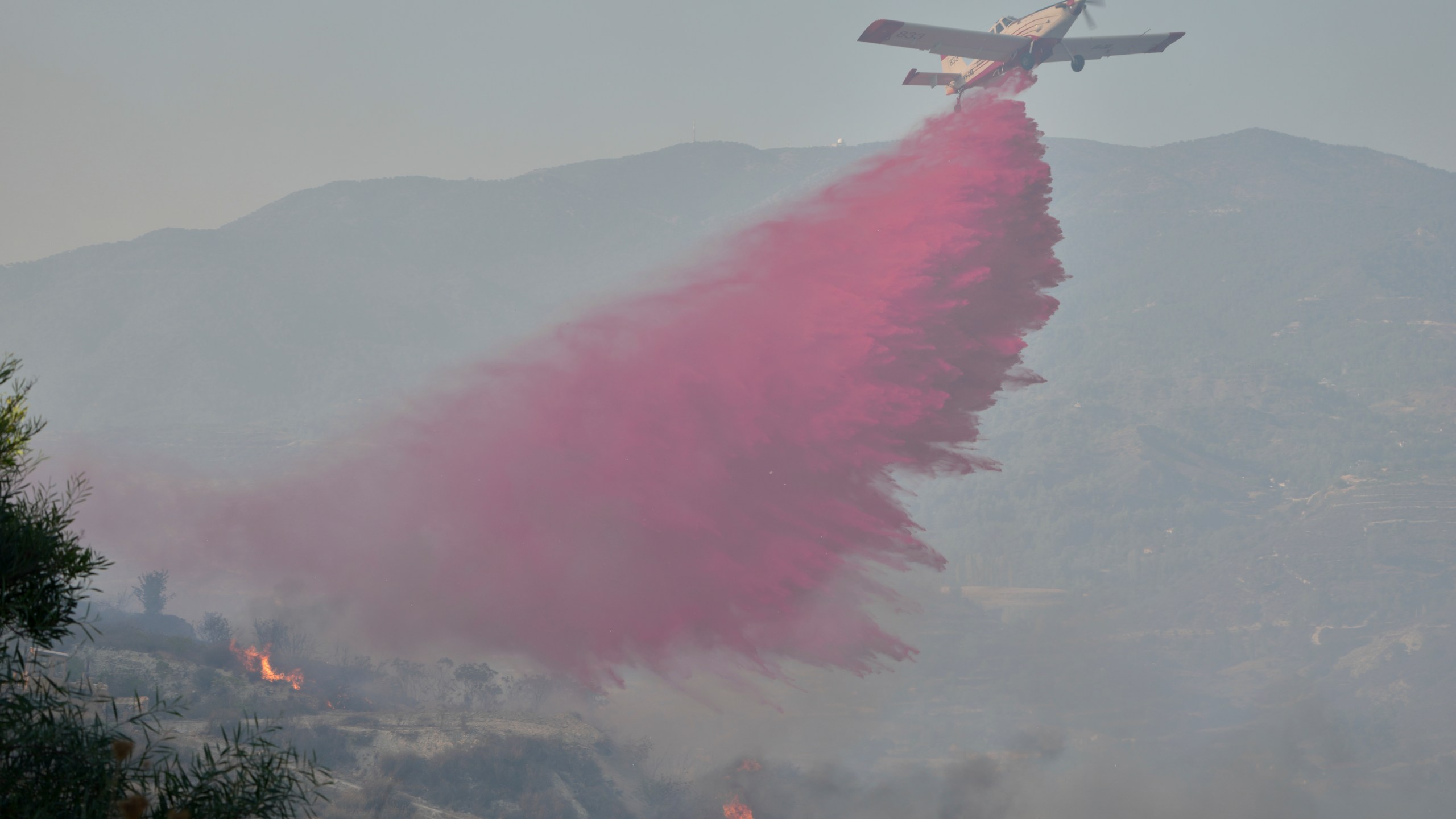 A British aircraft drops retardant liquid on the blazes in Omodos village, Cyprus, during a massive wildfire on the southern side of the east Mediterranean island nation's Troodos mountain range, Thursday, July 24, 2025. (AP Photo/Petros Karadjias)