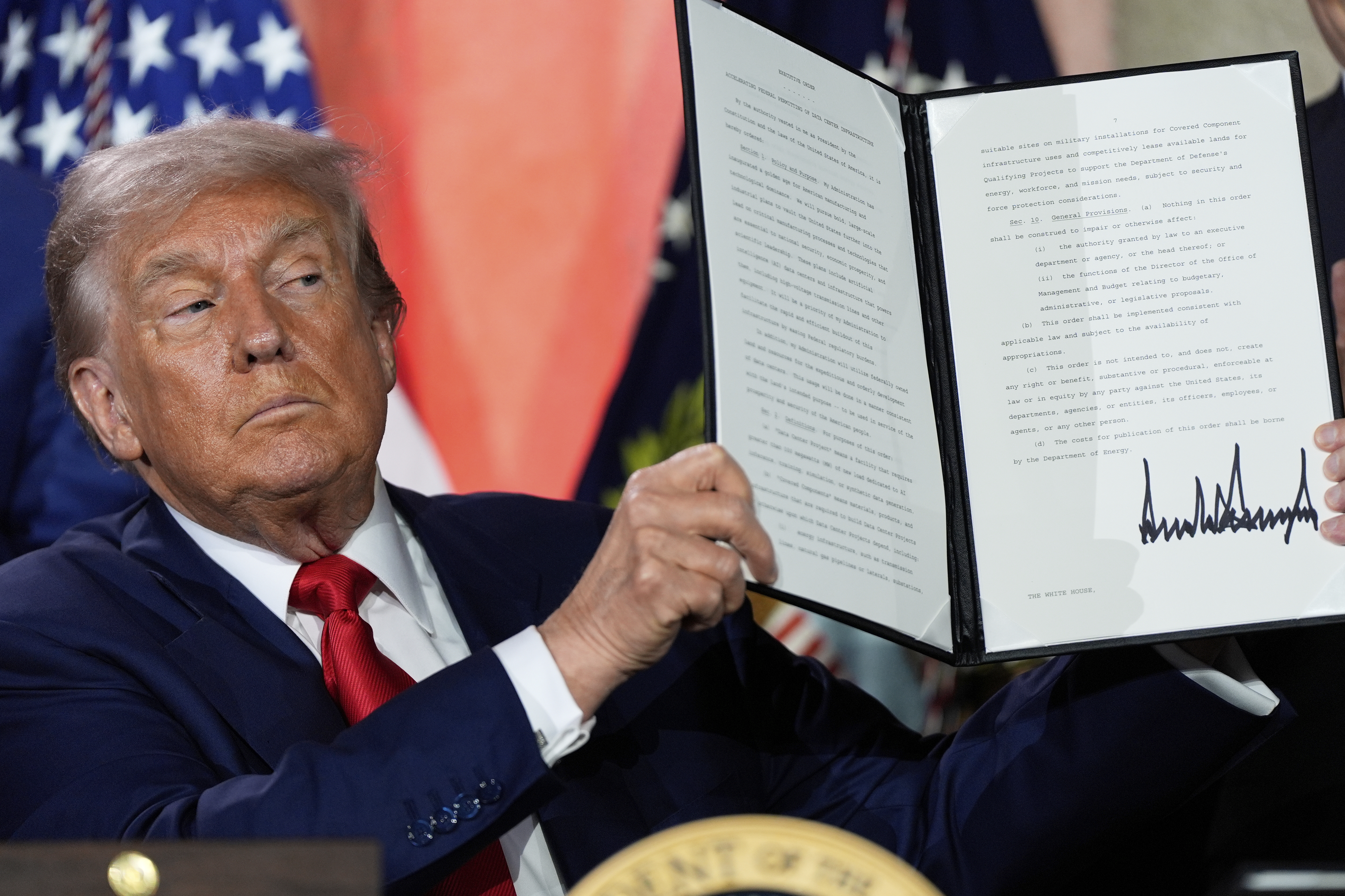 President Donald Trump holds a signed executive order after speaking during an AI summit at the Andrew W. Mellon Auditorium, Wednesday, July 23, 2025, in Washington. (AP Photo/Julia Demaree Nikhinson)