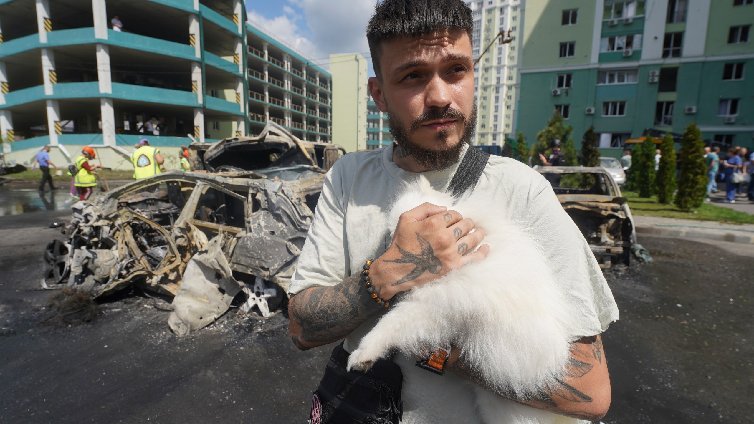 A man comforts his dog following a Russian attack that hit a residential area in Kharkiv, Ukraine, Thursday, July 24, 2025. (AP Photo/Andrii Marienko)