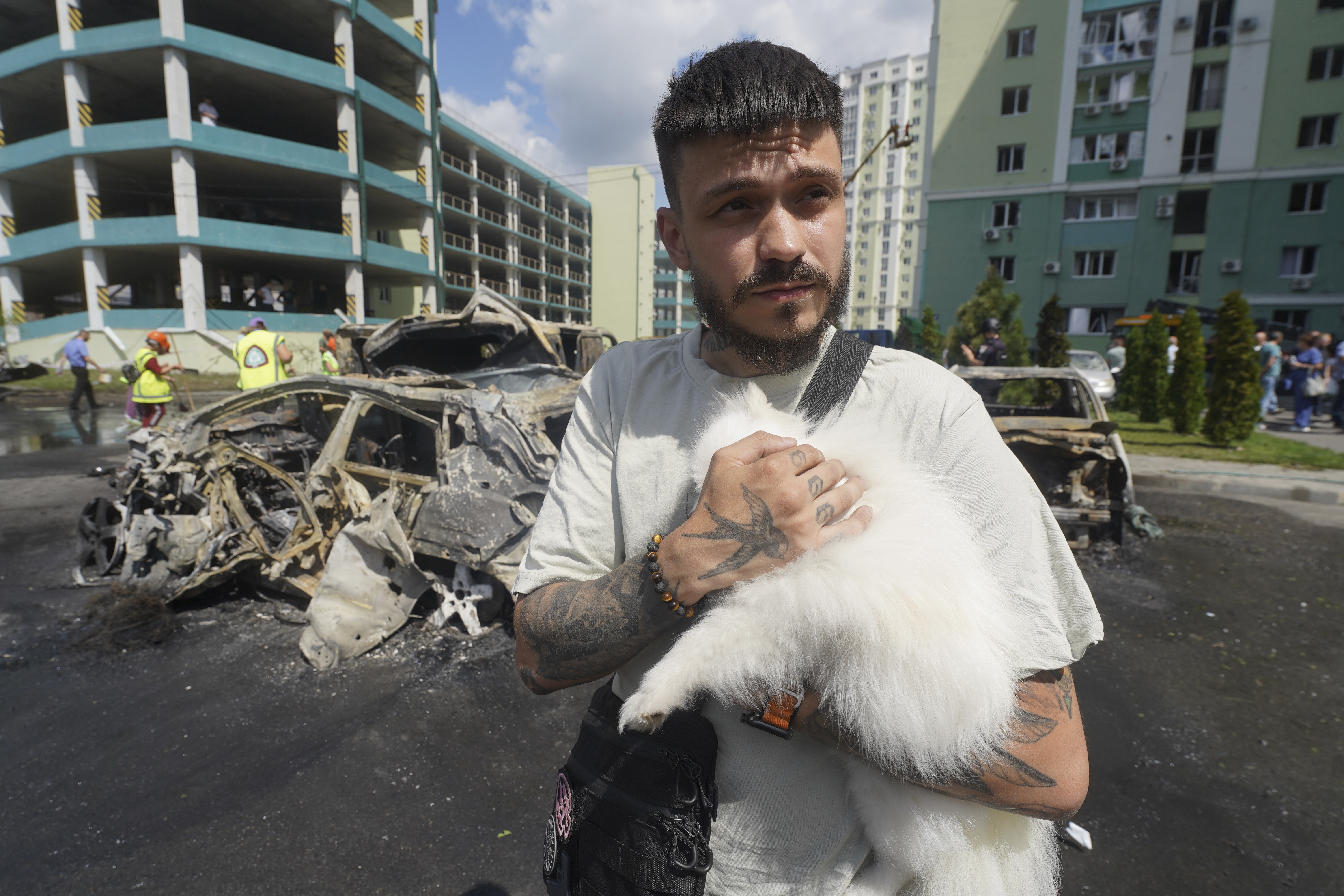 A man comforts his dog following a Russian attack that hit a residential area in Kharkiv, Ukraine, Thursday, July 24, 2025. (AP Photo/Andrii Marienko)