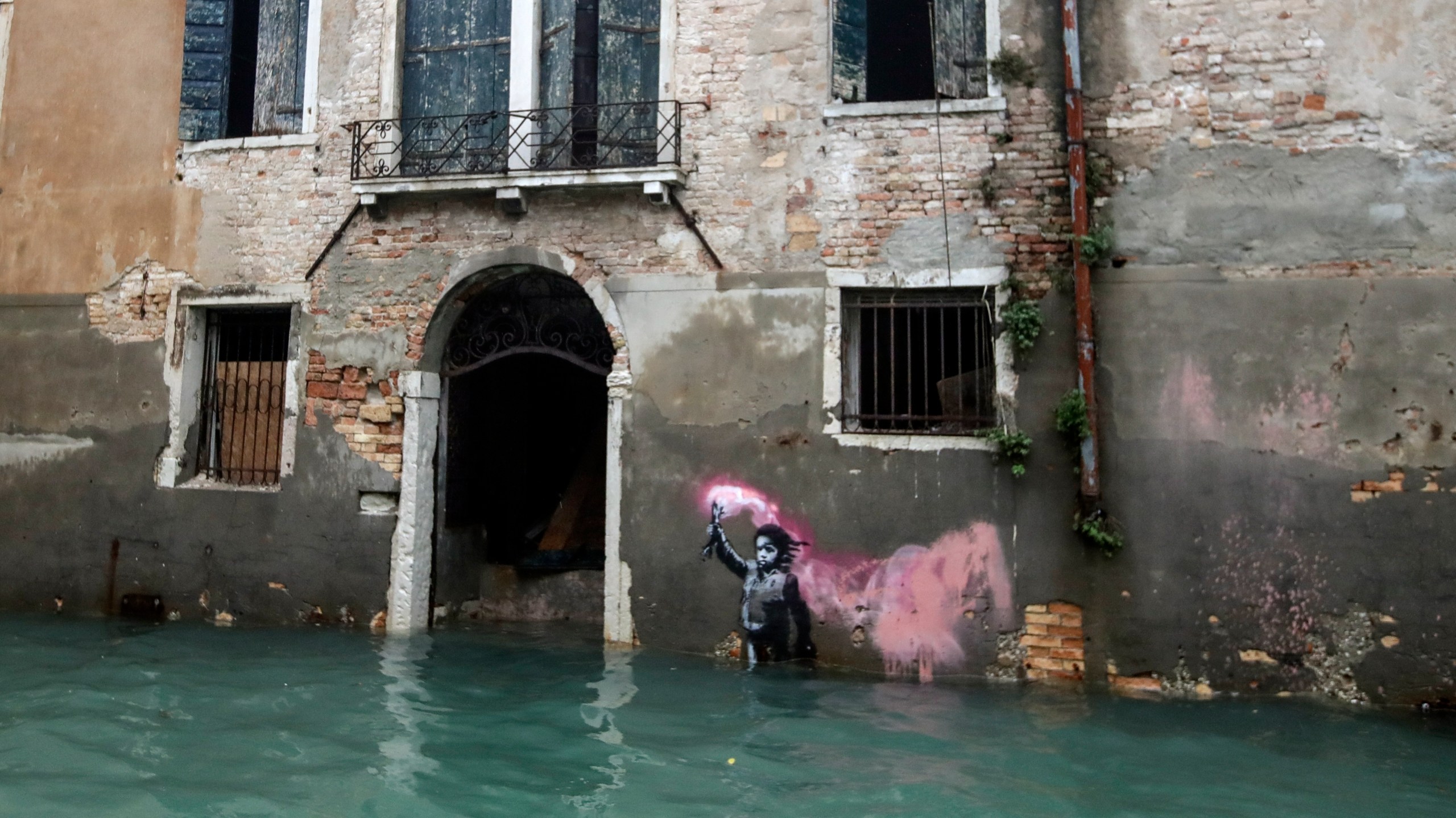 FILE - The Bansky work 'The Migrant Child' is partially submerged in Venice, Italy, Nov. 15, 2019. (AP Photo/Luca Bruno, File)
