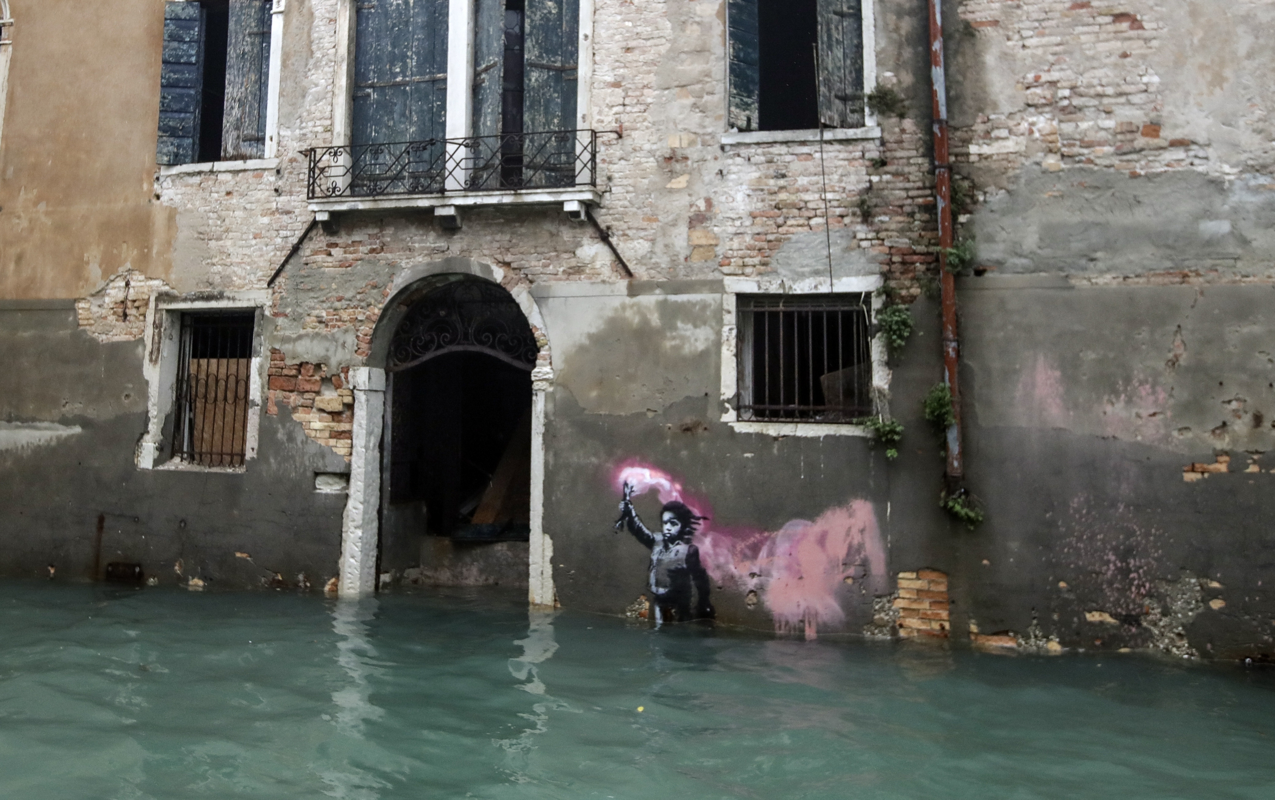 FILE - The Bansky work 'The Migrant Child' is partially submerged in Venice, Italy, Nov. 15, 2019. (AP Photo/Luca Bruno, File)