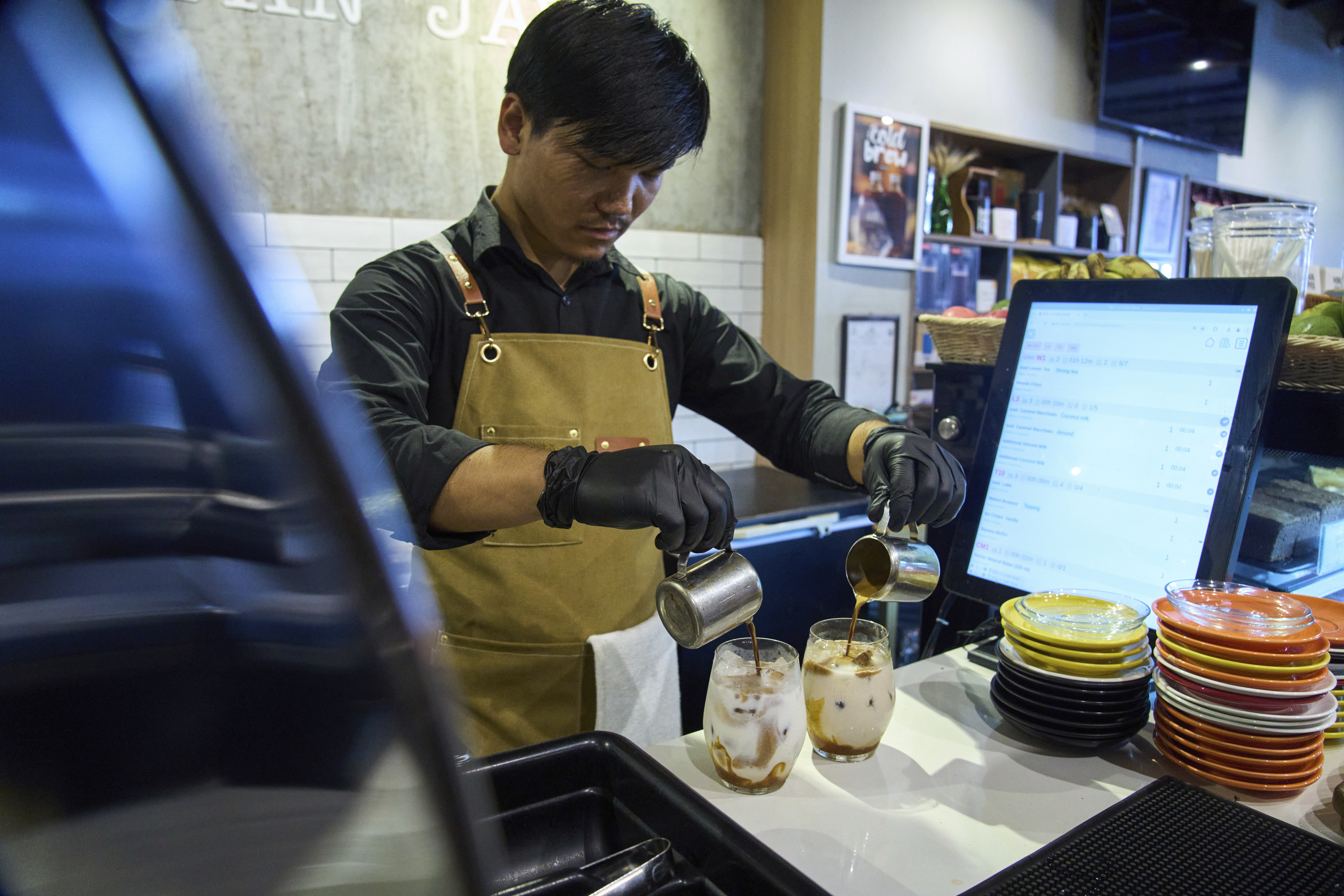 An employee prepares a coffee for a customer at Himalayan Java cafe at Boudhanath Stupa in Kathmandu, Nepal, Tuesday, June 10, 2025. (AP Photo/Niranjan Shrestha)