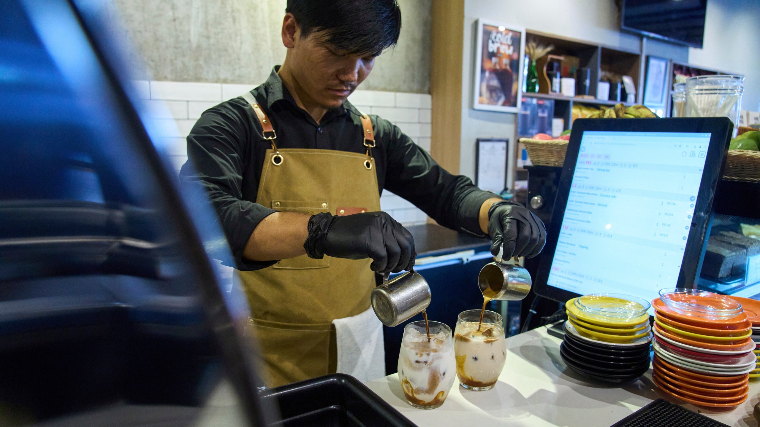 An employee prepares a coffee for a customer at Himalayan Java cafe at Boudhanath Stupa in Kathmandu, Nepal, Tuesday, June 10, 2025. (AP Photo/Niranjan Shrestha)