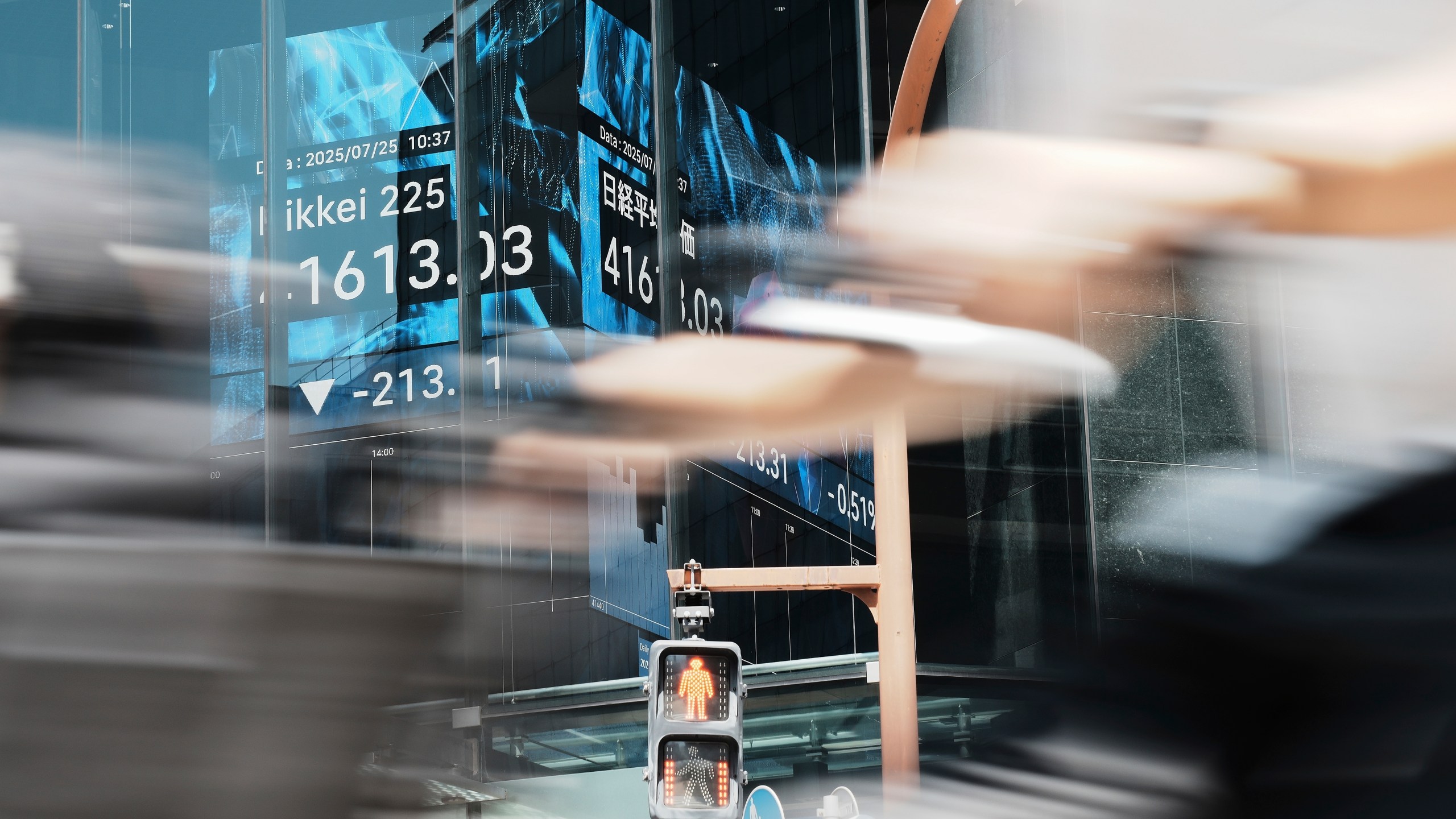 A person rides a bicycle past an electronic stock board showing Japan's Nikkei index at a securities firm Friday, July 25, 2025, in Tokyo. (AP Photo/Eugene Hoshiko)