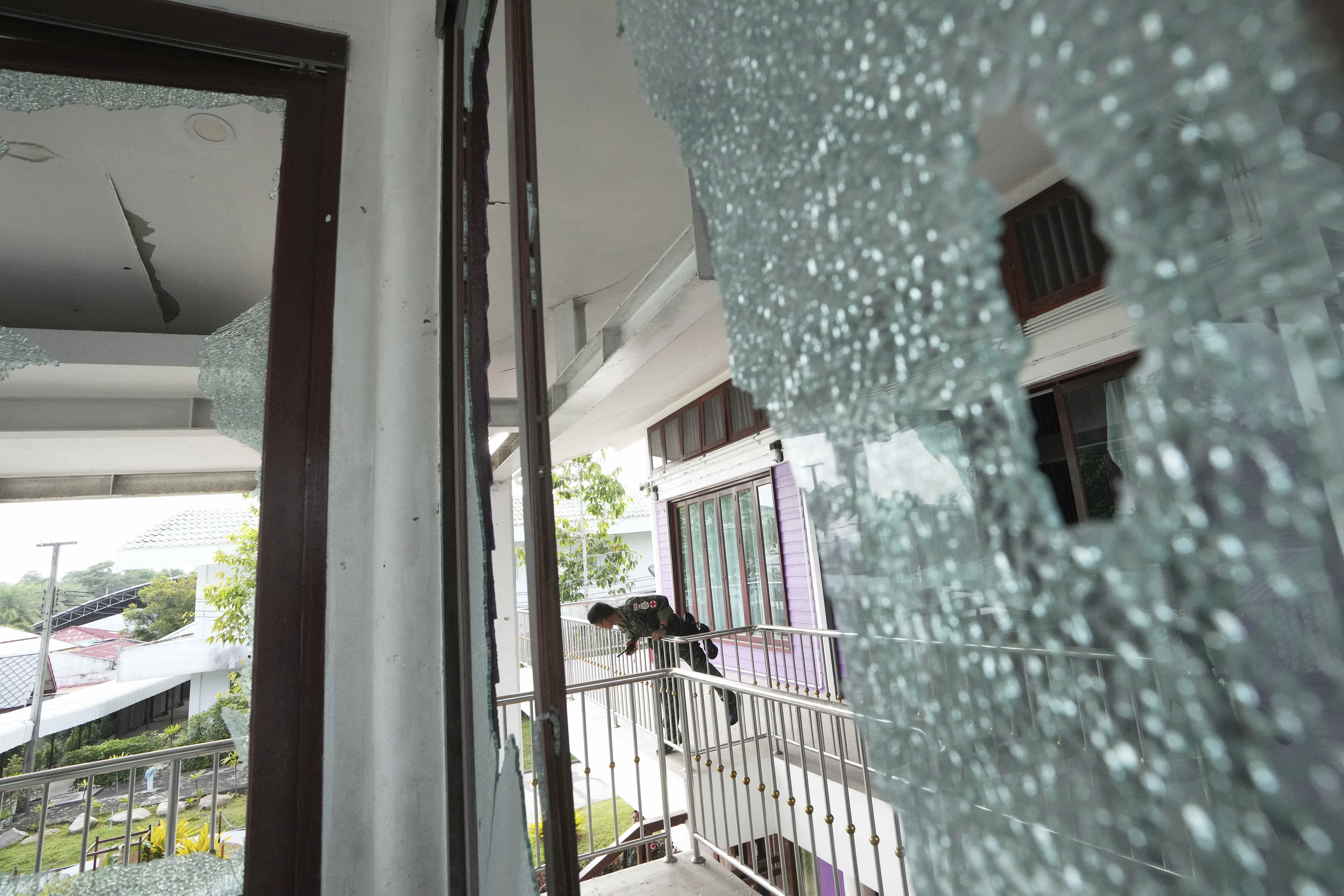A Thai soldier stands at the Phanom Dong Rak hospital damaged after Cambodia fired artillery shells in Surin Province, Thailand, Friday, July 25, 2025. (AP Photo/Sakchai Lalit)