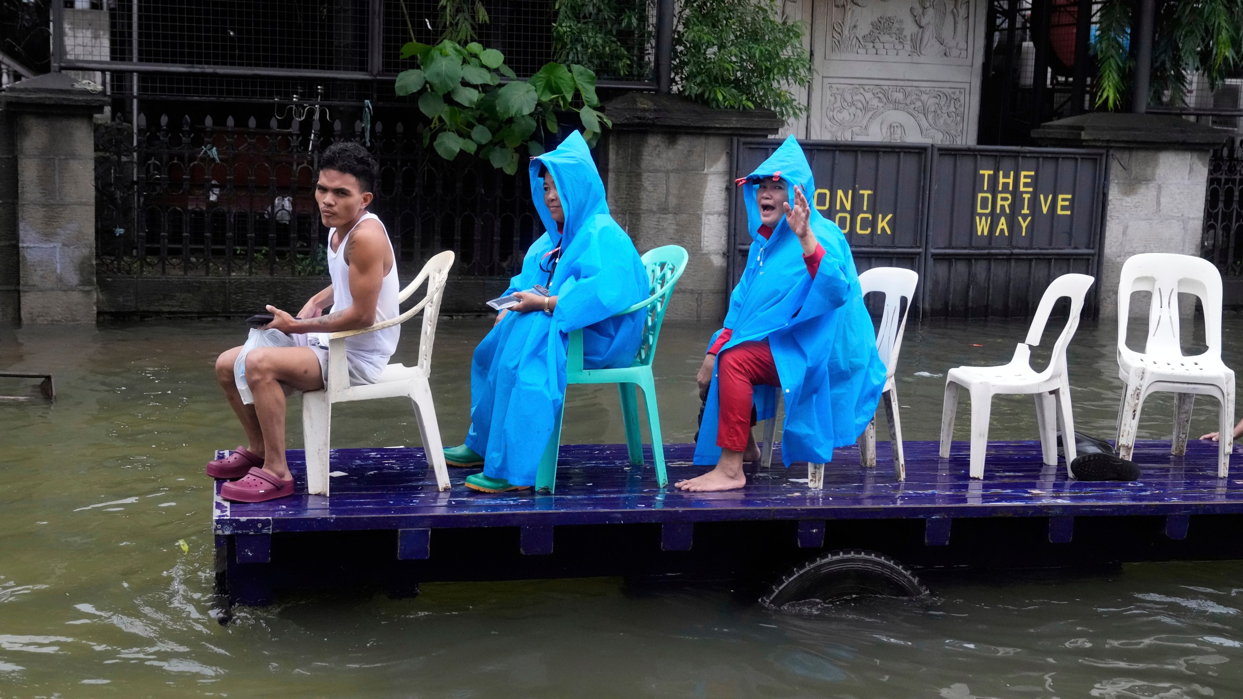 Residents ride a cart along a flooded road as Typhoon Co-may intensified seasonal monsoon rains at Malabon city, Philippines on Friday, July 25, 2025. (AP Photo/Aaron Favila)