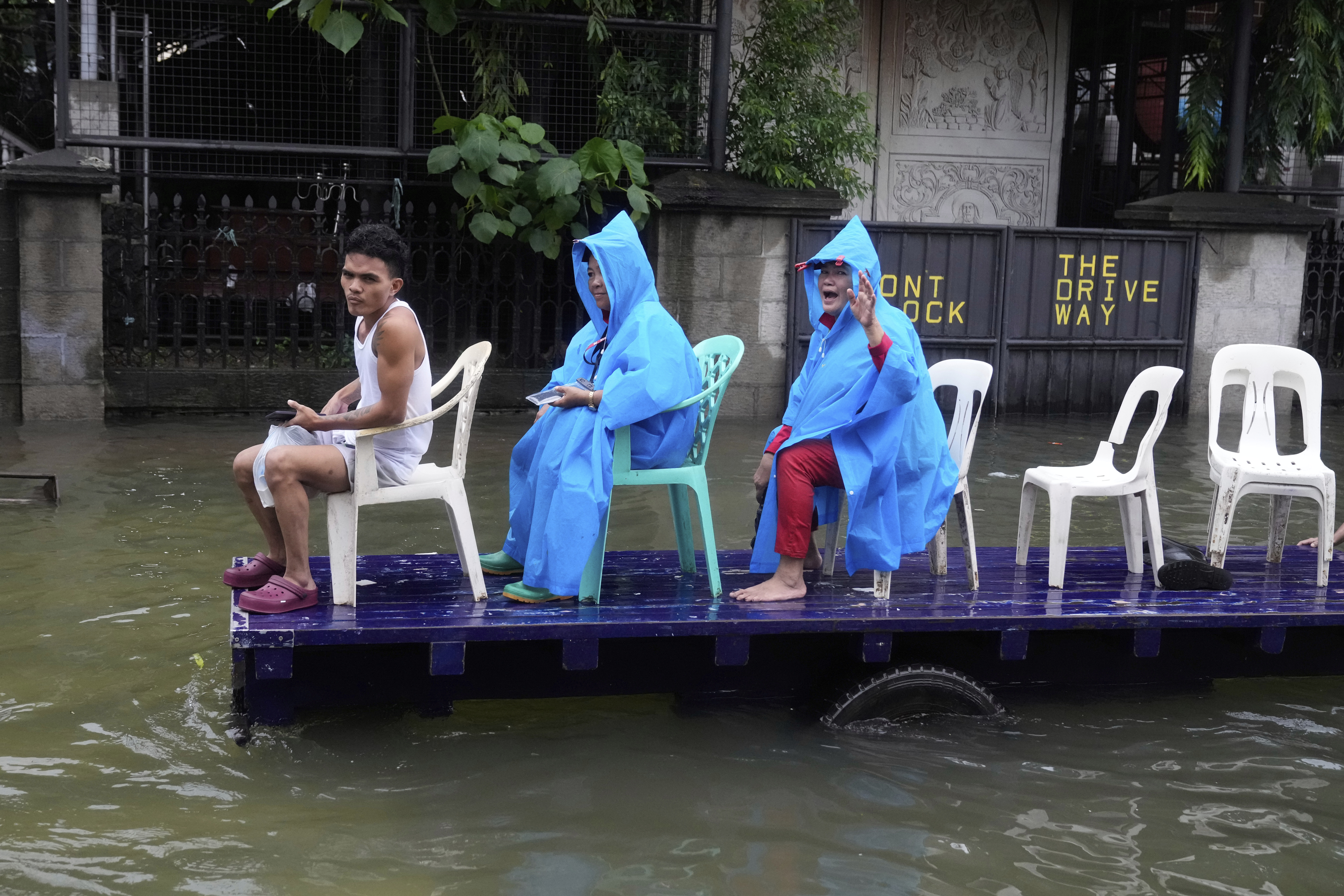 Residents ride a cart along a flooded road as Typhoon Co-may intensified seasonal monsoon rains at Malabon city, Philippines on Friday, July 25, 2025. (AP Photo/Aaron Favila)