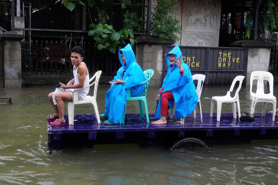 Residents ride a cart along a flooded road as Typhoon Co-may intensified seasonal monsoon rains at Malabon city, Philippines on Friday, July 25, 2025. (AP Photo/Aaron Favila)