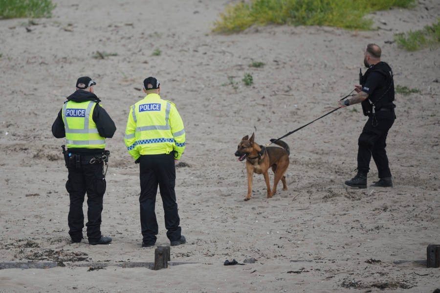 A police dog handler walks his dog on the beach to help with security at the Trump Turnberry golf course in Turnberry, Scotland, Friday, July 25, 2025, ahead of President Trump's visit Scotland. (AP Photo/Alastair Grant)