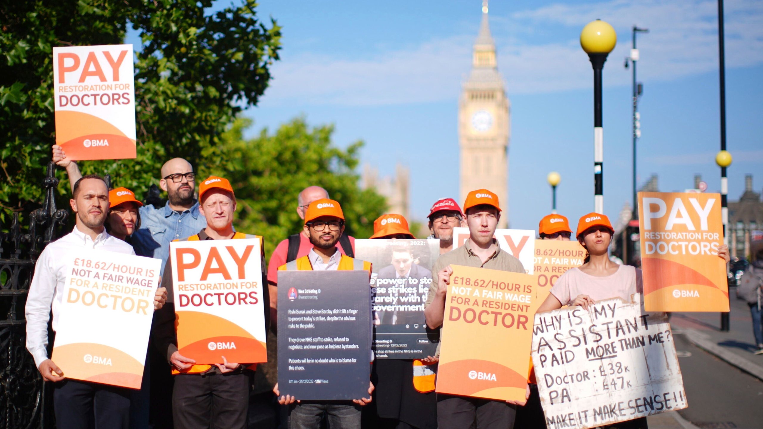 NHS resident doctors hold placards outside St Thomas' Hospital in London, as resident doctors in England, formerly referred to as junior doctors, begin a five-day strike after talks with the government collapsed over pay, Friday, July 25, 2025. ( James Manning/PA via AP)