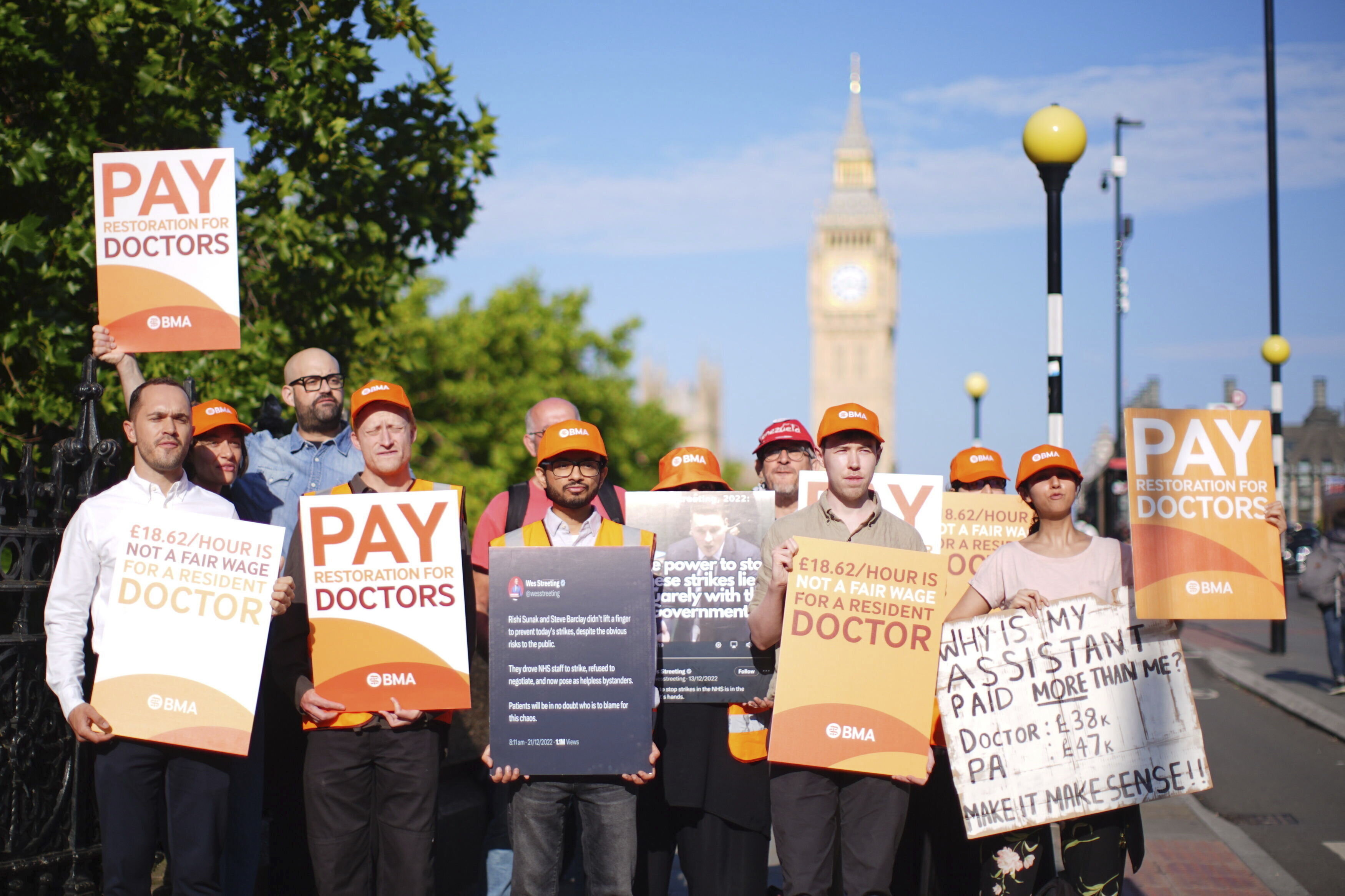 NHS resident doctors hold placards outside St Thomas' Hospital in London, as resident doctors in England, formerly referred to as junior doctors, begin a five-day strike after talks with the government collapsed over pay, Friday, July 25, 2025. ( James Manning/PA via AP)