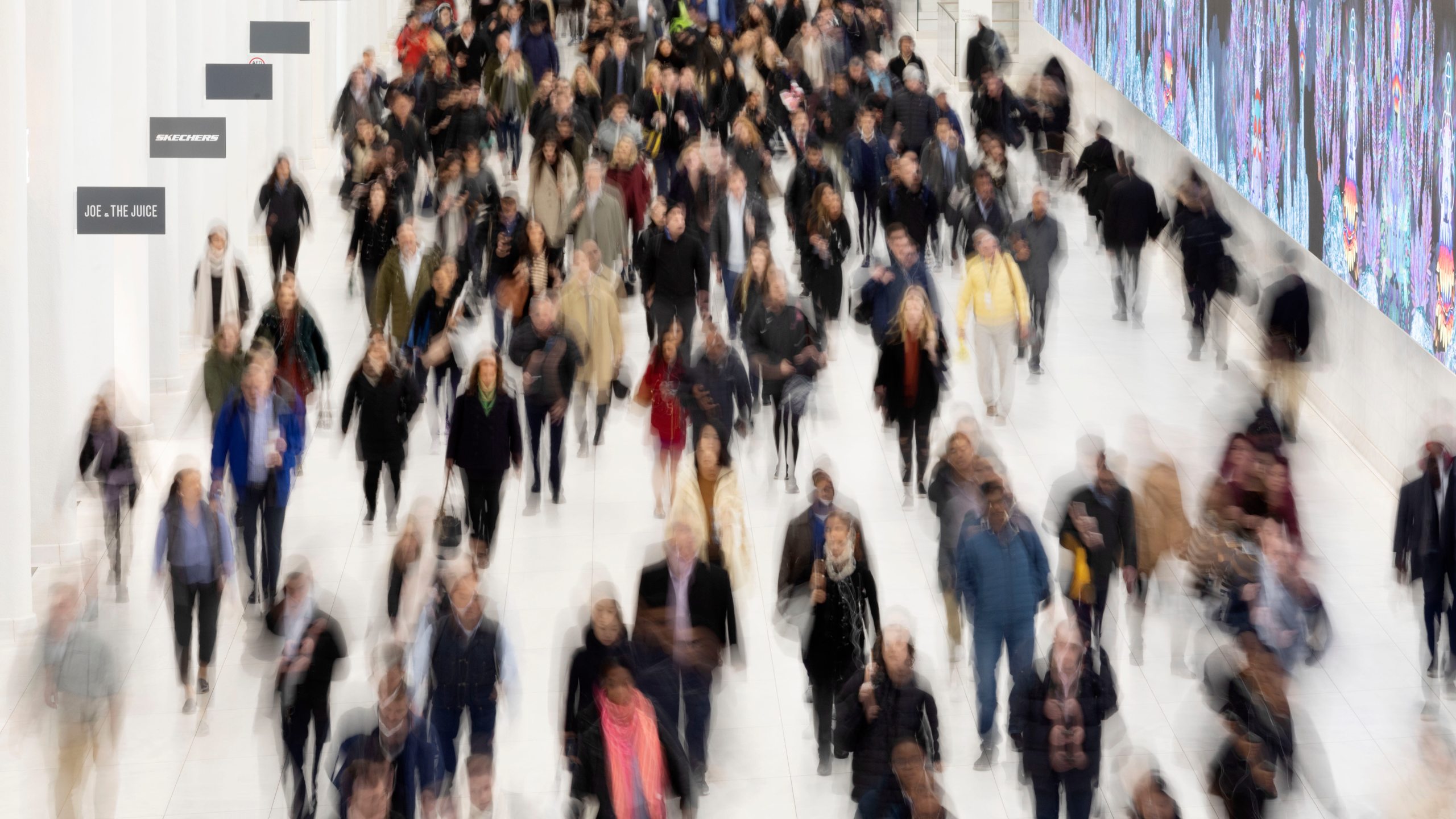 FILE - Commuters walk along a corridor in the World Trade Center, Monday, Nov. 18, 2019 in New York. (AP Photo/Mark Lennihan, File)