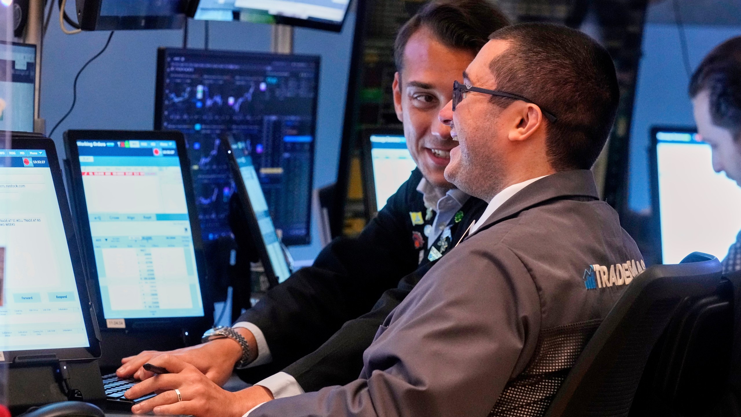 Traders Drew Cohen, foreground, and Dylan Halvorsan work on the floor of the New York Stock Exchange, Monday, July 21, 2025. (AP Photo/Richard Drew)