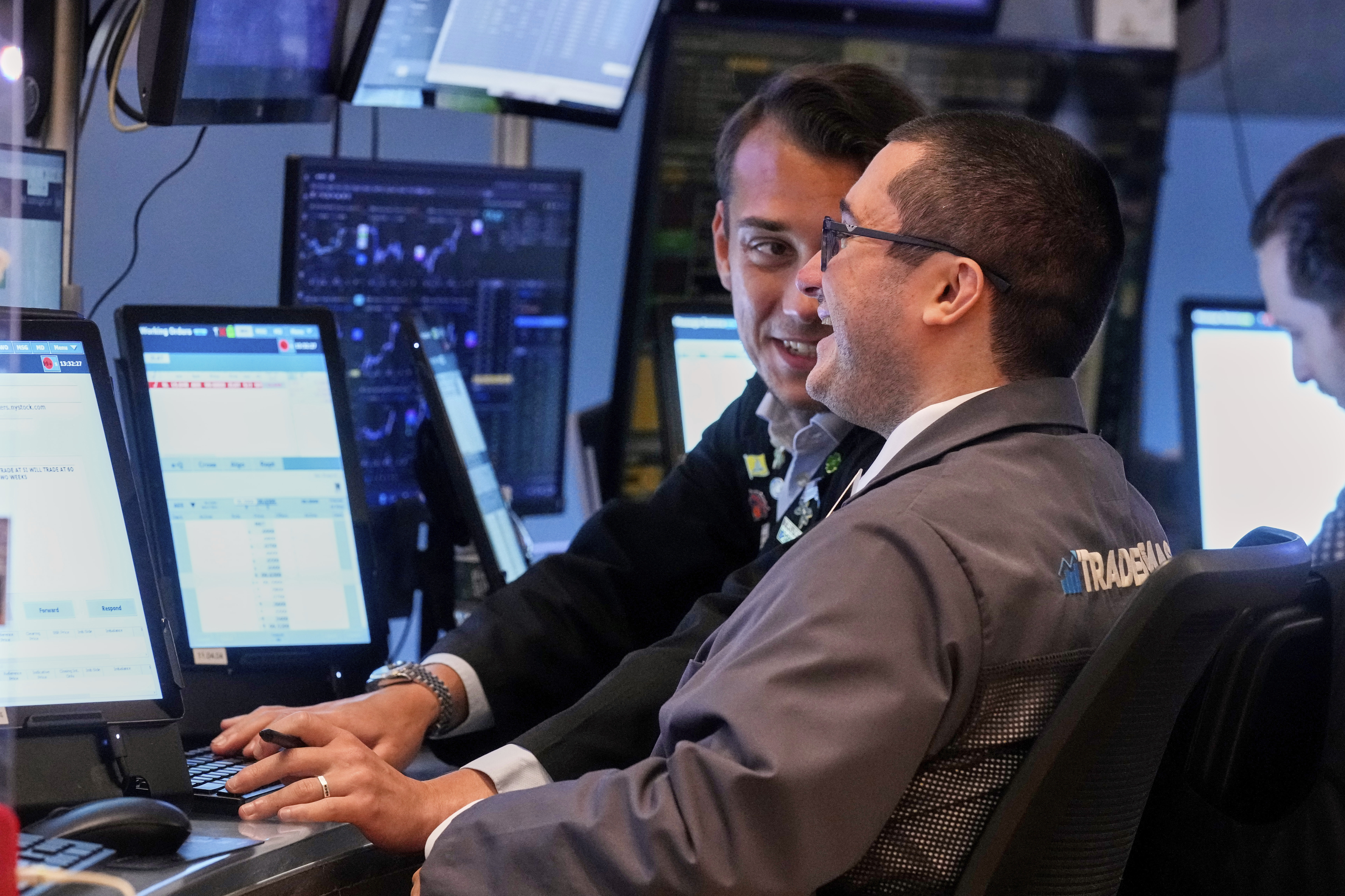 Traders Drew Cohen, foreground, and Dylan Halvorsan work on the floor of the New York Stock Exchange, Monday, July 21, 2025. (AP Photo/Richard Drew)