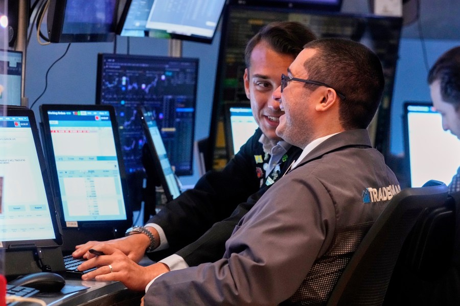Traders Drew Cohen, foreground, and Dylan Halvorsan work on the floor of the New York Stock Exchange, Monday, July 21, 2025. (AP Photo/Richard Drew)