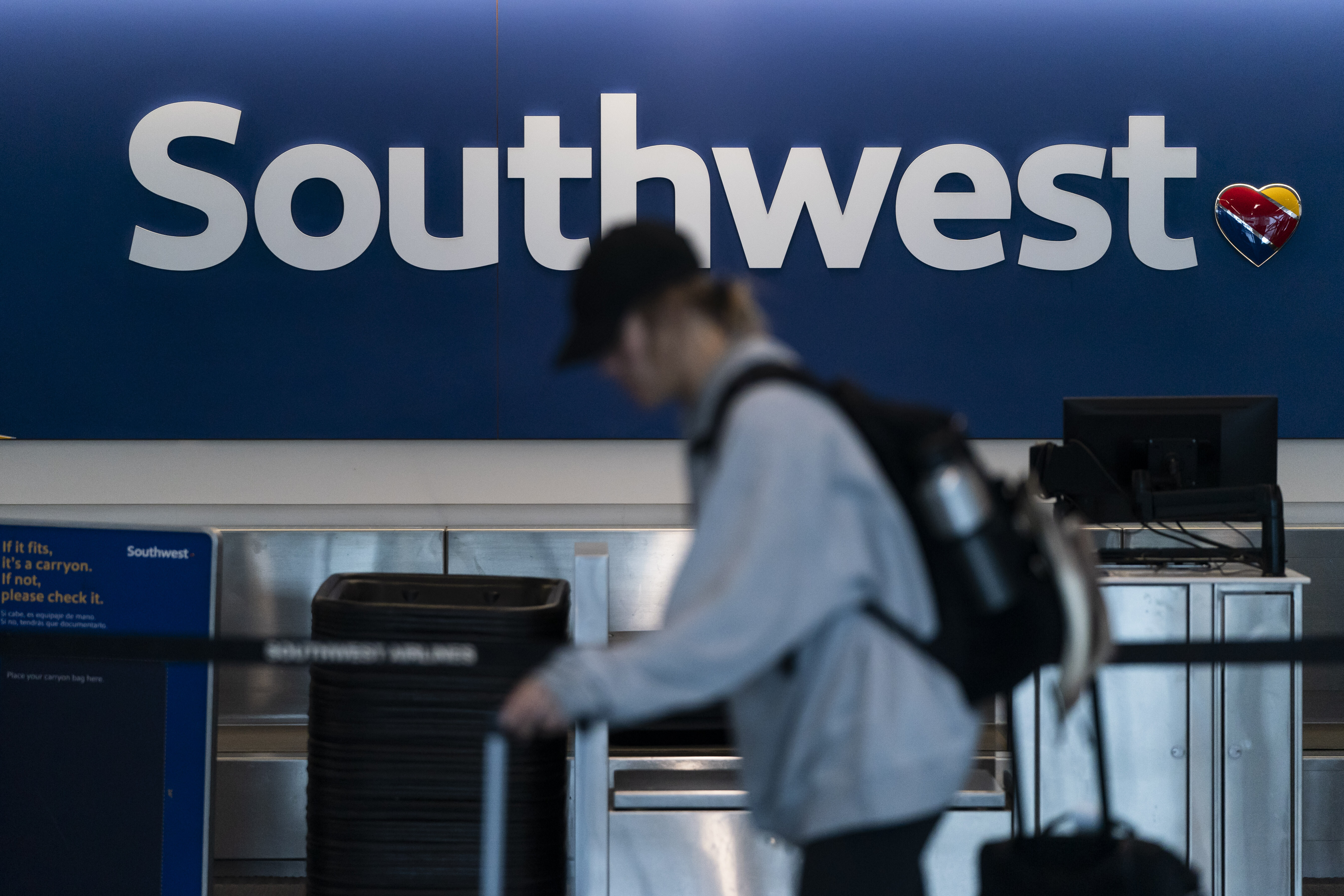 FILE - A traveler walks through the Southwest Airlines ticketing counter area at the Los Angeles International Airport in Los Angeles, April 18, 2023. (AP Photo/Jae C. Hong, File)