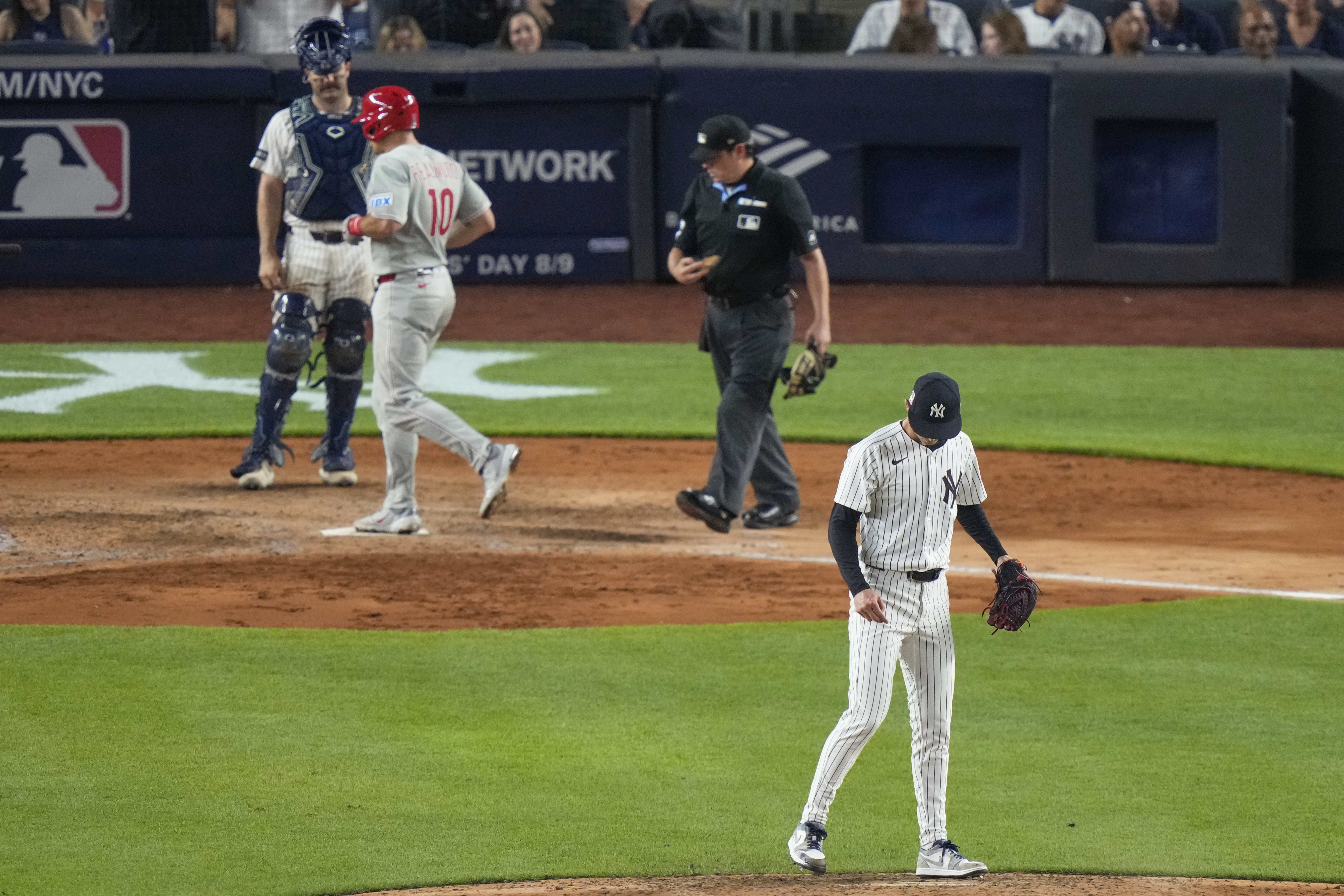 New York Yankees pitcher Luke Weaver, right, looks down as Philadelphia Phillies' J.T. Realmuto reaches home plate after hitting a three-run home run during the seventh inning of a baseball game Friday, July 25, 2025, in New York. (AP Photo/Frank Franklin II)