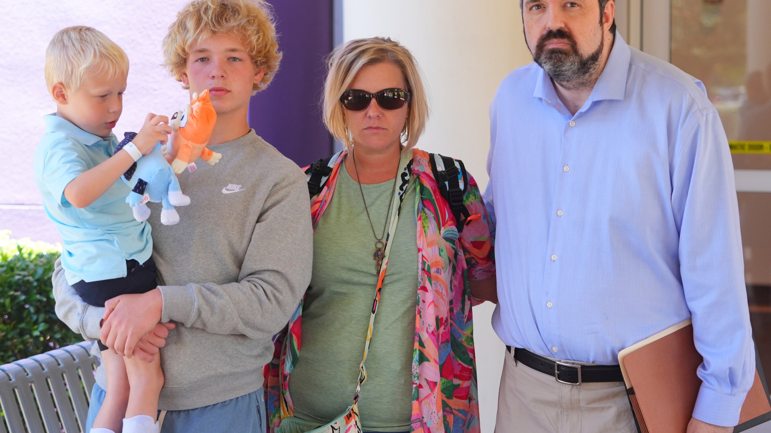 Attorney Chris McGreal, right, poses for a photo with Jessica Haugh, center right, and her sons Ryder Ponder, 14, center left, and Rustin 'Rusty' Haugh, 4, after a doctor's appointment for Rusty in Dallas, Wednesday, July 23, 2025. (AP Photo/LM Otero)