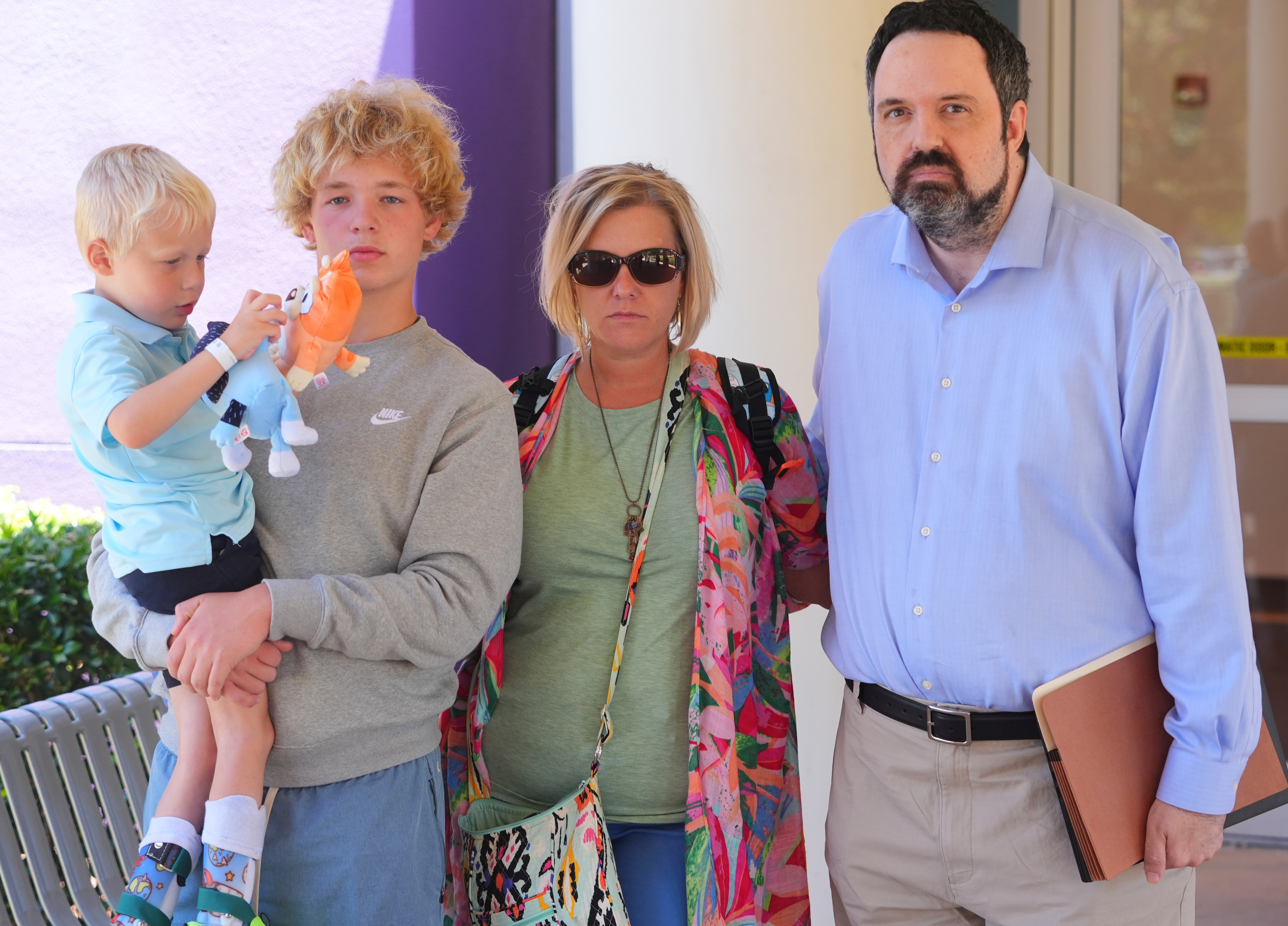 Attorney Chris McGreal, right, poses for a photo with Jessica Haugh, center right, and her sons Ryder Ponder, 14, center left, and Rustin 'Rusty' Haugh, 4, after a doctor's appointment for Rusty in Dallas, Wednesday, July 23, 2025. (AP Photo/LM Otero)