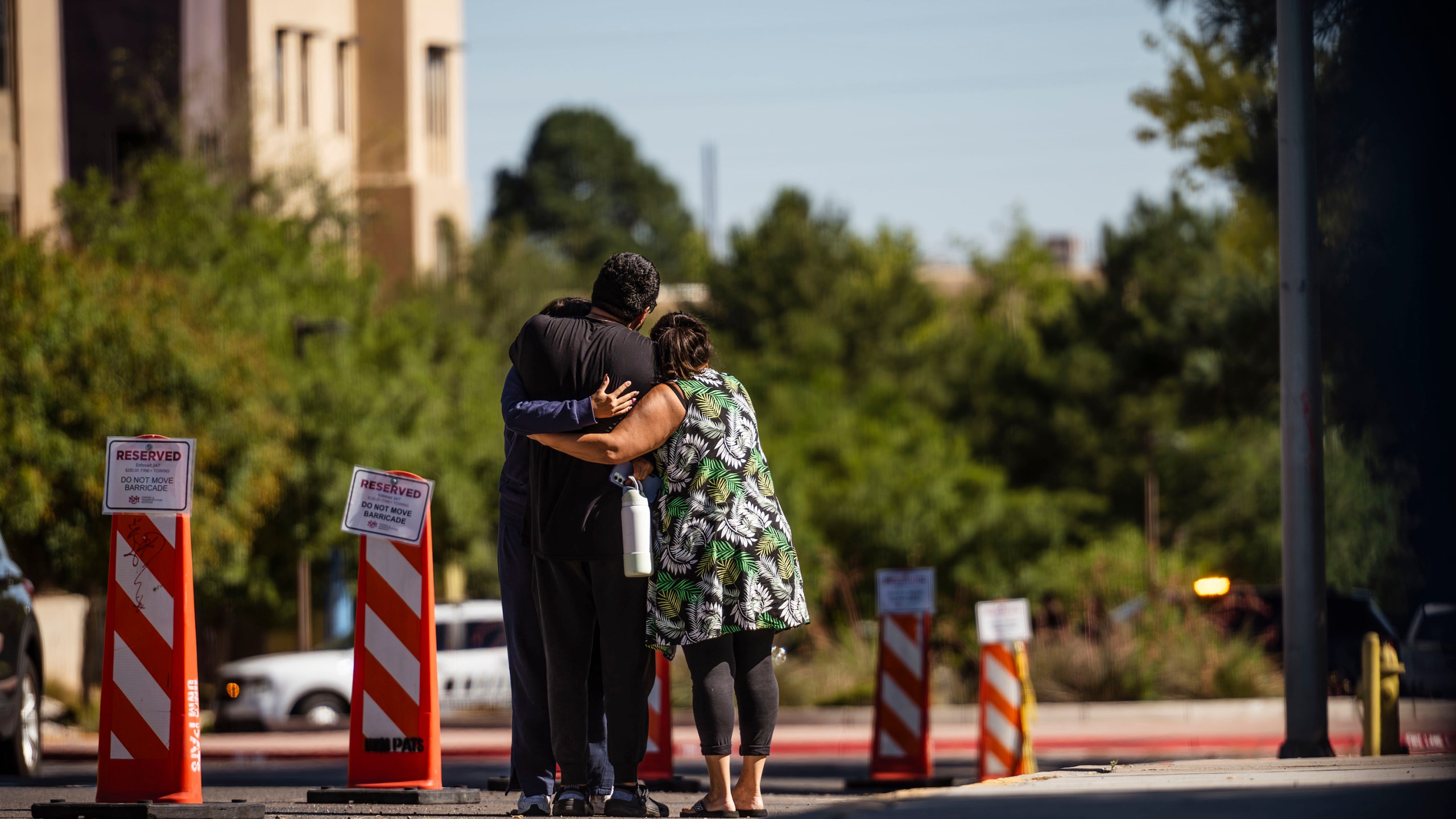 Family members embrace at the University of New Mexico Central Campus after a deadly shooting at Casas del Rio (Gila), a student housing center, early Friday, July 25, 2025 in Albuquerque, N.M. (Chancey Bush/The Albuquerque Journal via AP)